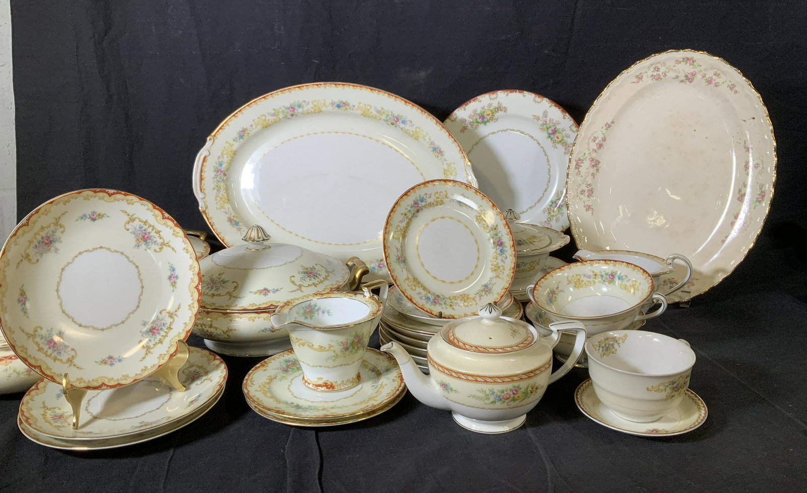 Near Coordinating Porcelain Dinnerware 29: NORITAKE ORADELL PATTERN set consisting of two serving bowls with lids and gilt handles, 3 luncheon plates, NORITAKE LINDEN PATTERN set 2 dessert dishes, creamer, saucer, sugar bowl with lid ( chip to