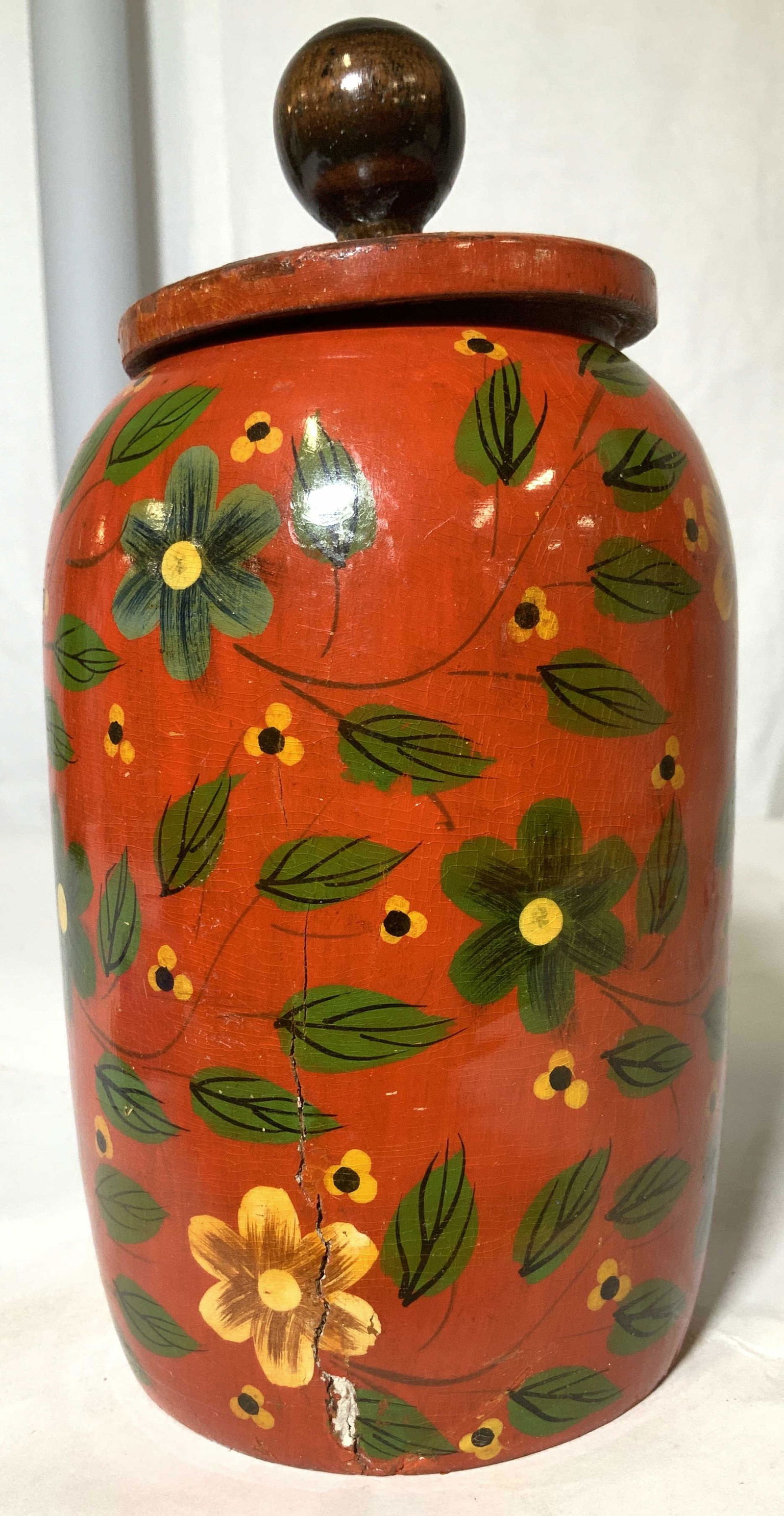 Hand Painted Wood Lacquer Jar: Hand carved jar made of wood, lacquered red with yellow and green flowers, had lid with orb finial. Carved in half way to reach in. 8 in ht. 4.5 in w. Light wear to paint on lid, exterior crack to sid