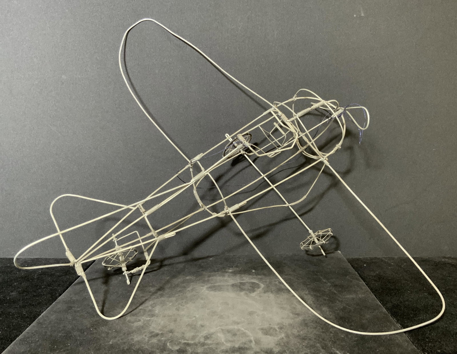 Handmade Metal Wire Airplane Sculpture: A airplane sculpture crafted from metal wire. Metal is silver tone gray. Piece has three wheels. Approx. 5H x 15W in. Metal wire sculpture, arts and crafts, decorative arts, airplane model, plane mode