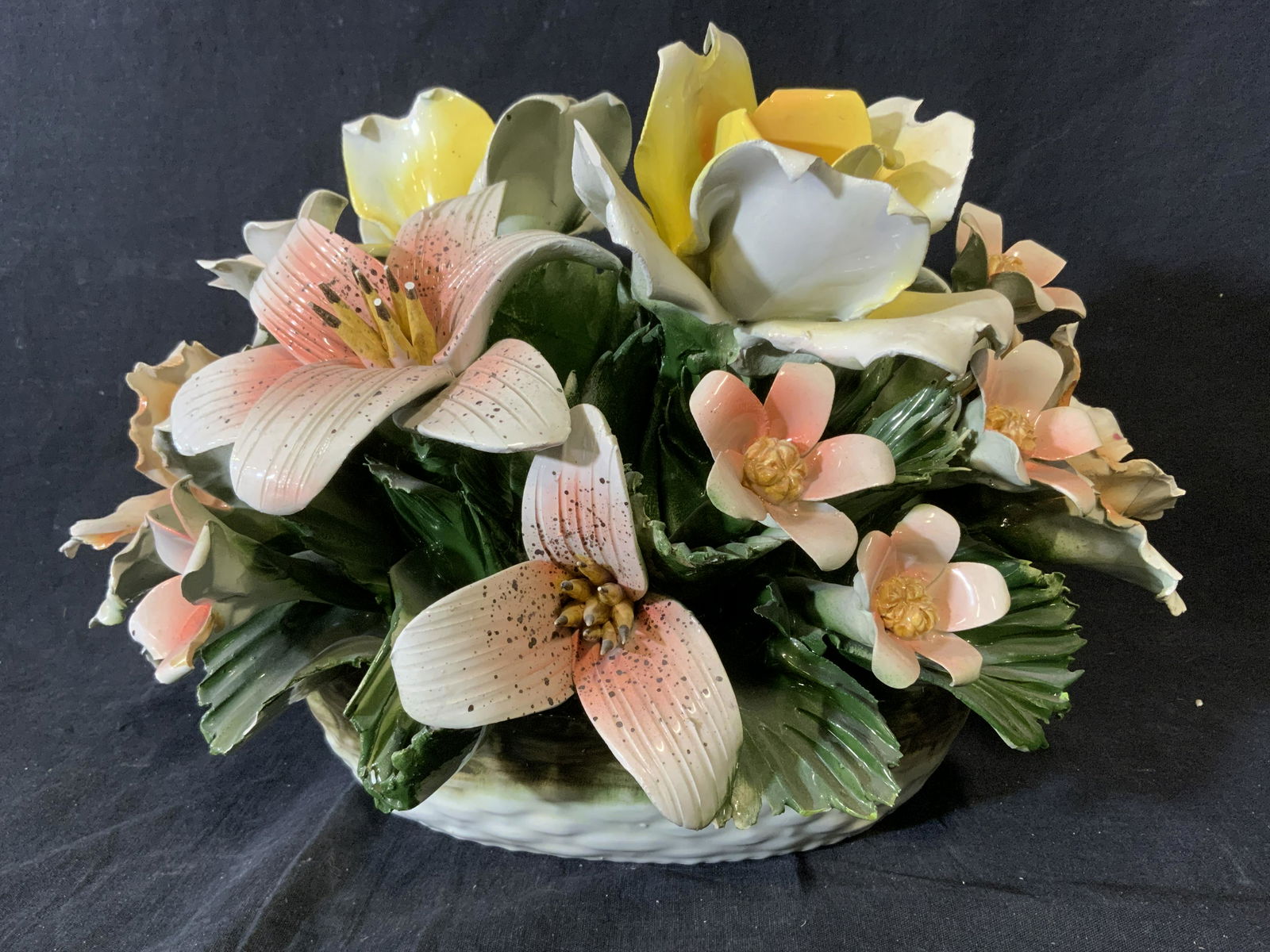 Vintage Capodimonte Style Floral Bouquet Decor: Vintage ceramic bouquet, piece is hand painted. Crafted to resemble a bouquet in a bracket. A number of flowers and leaves have chipped. Measures approx 10 inches H, and 15 inches W. Trade mark on und