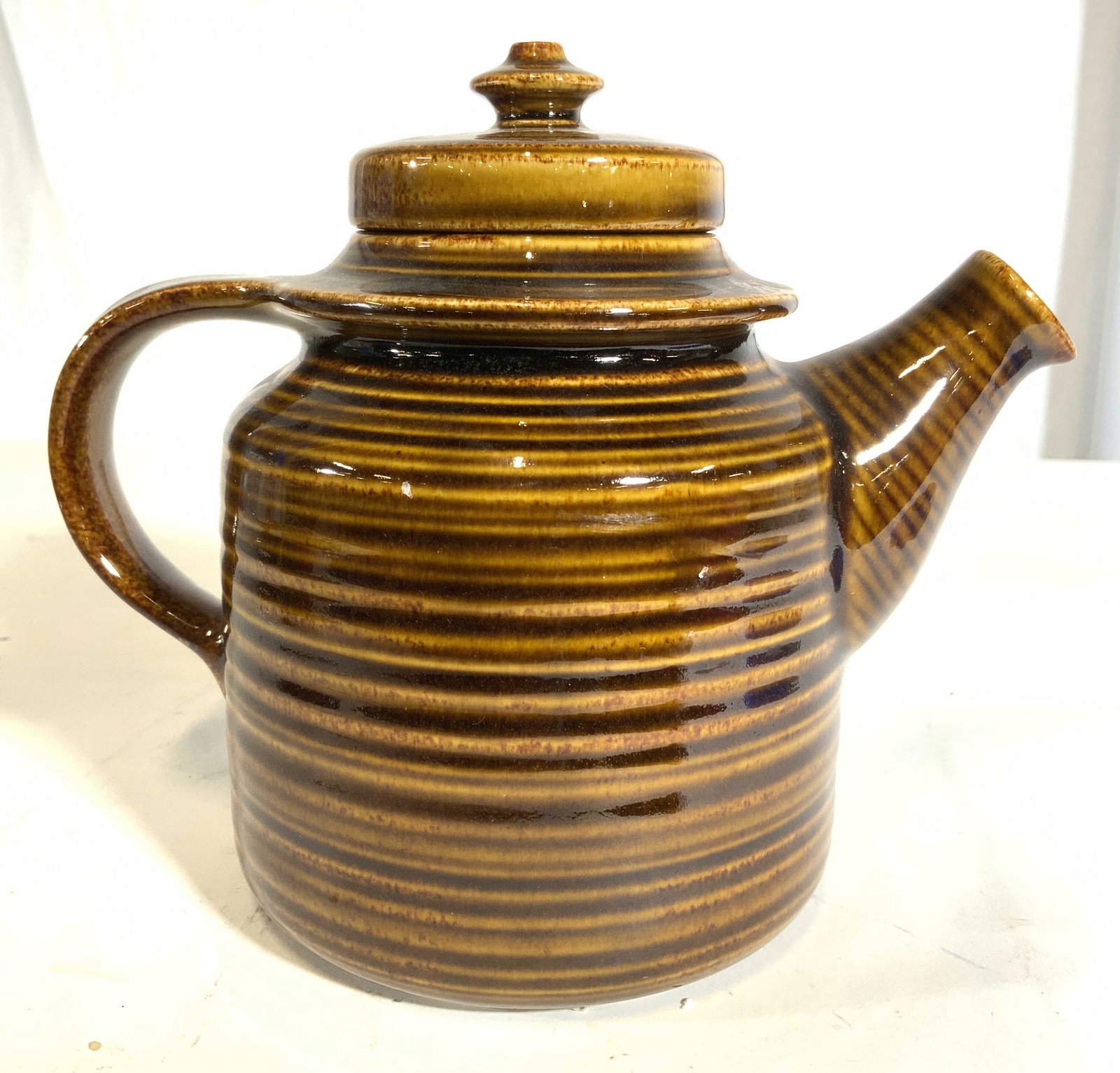 ARABIA Stoneware Lidded Coffee Pot: Underside is marked ARABIA MADE IN FINLAND. Piece appears to be stoneware, possibly porcelain. Piece has tones of light and dark brown with stripe detail. Piece measures approx 7 inches tall 9 inches 