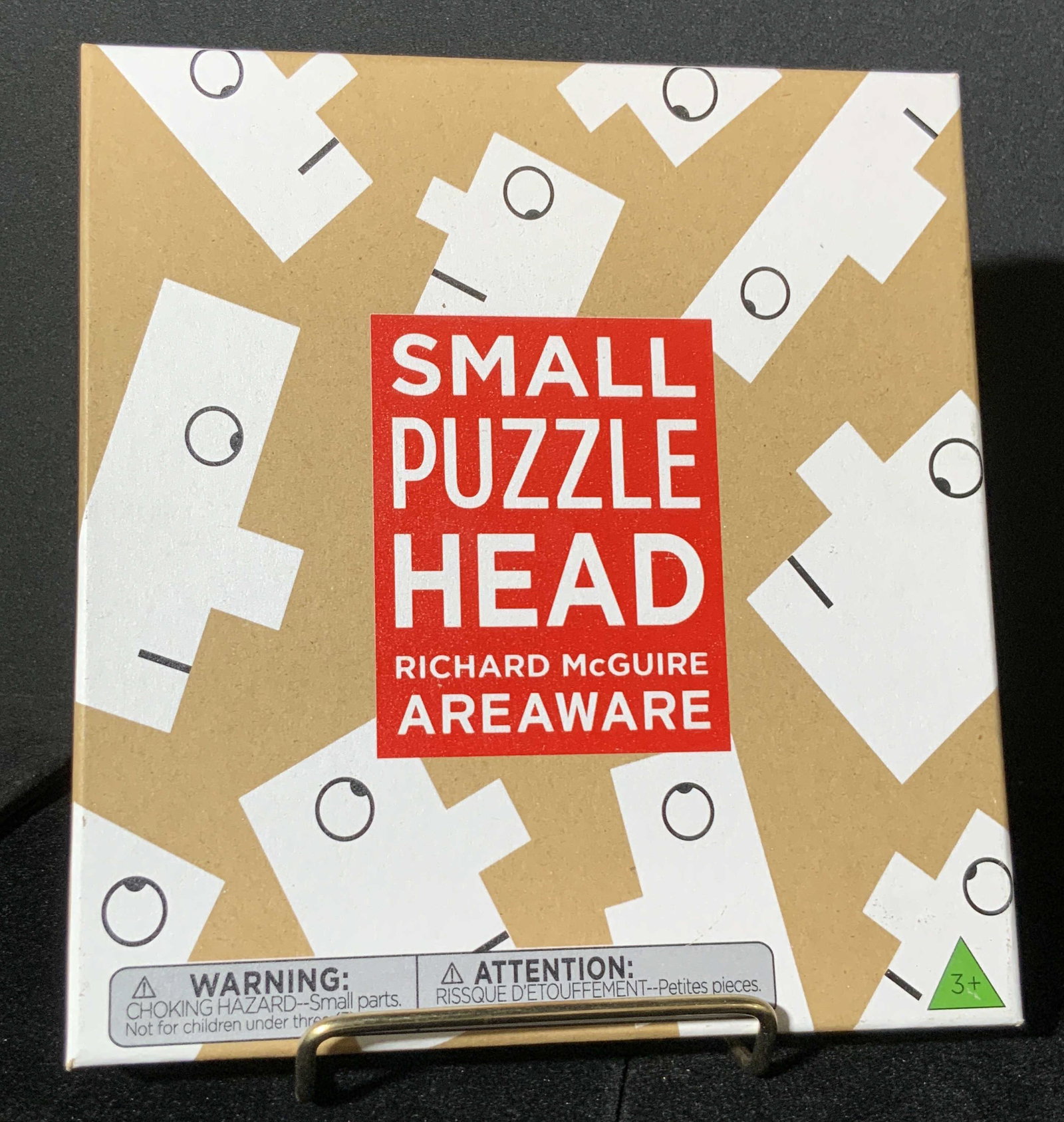 SMALL PUZZLEHEAD RICHARD MCGUIRE, Org Box: A puzzle inspired by the doodles of Richard McGuire, a famous cartoonist. Obverse reads SMALL PUZZLEHEAD, RICHARD MCGUIRE AREAWARE. Piece comes in original box. Some drawings on interior card. Approx.