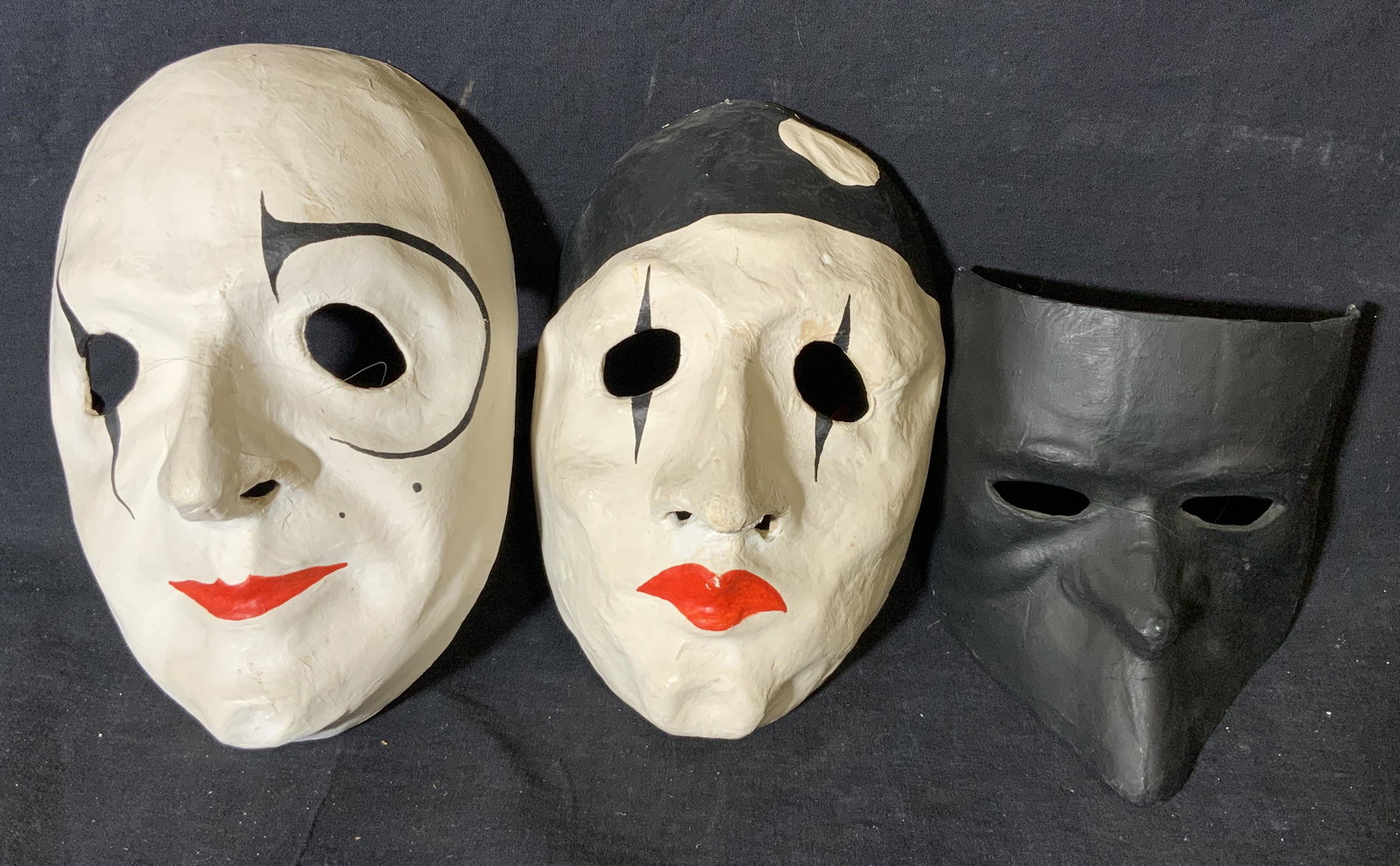 Group 3 Papier-mâché Masks: Group 3 papier-mache masks, labels to reverse of all read ‘Laboratorio Artiguano Maschere’, one of three painted entirely black, two of three hand painted in black white and red, largest of the th