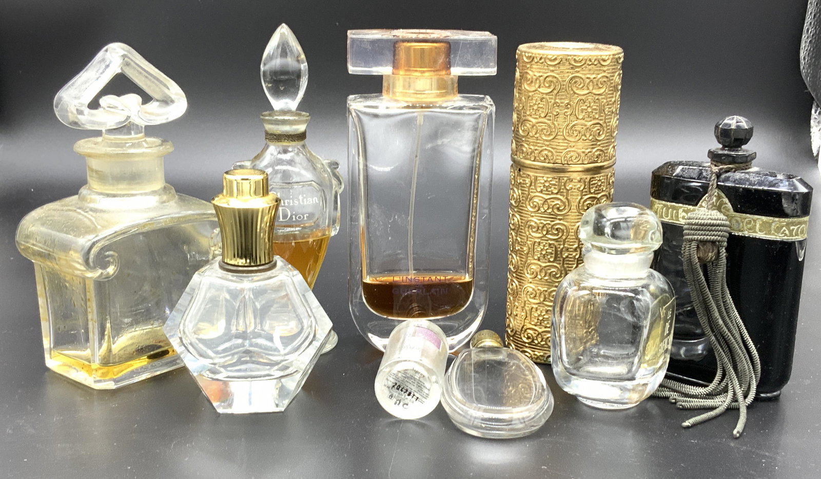 Collectible lot 9 French Perfume Bottles, more: Bottles include L’INSTANT DE GUERLAIN, GUERLAIN BACCARAT HALLMARKED PERFUME BOTTLE, Step by VIEUX ROUEN, GIVENCHY, CHRISTIAN DIOR, Nuit De Noel original black opaque perfume bottle, c. 1920s, CARON