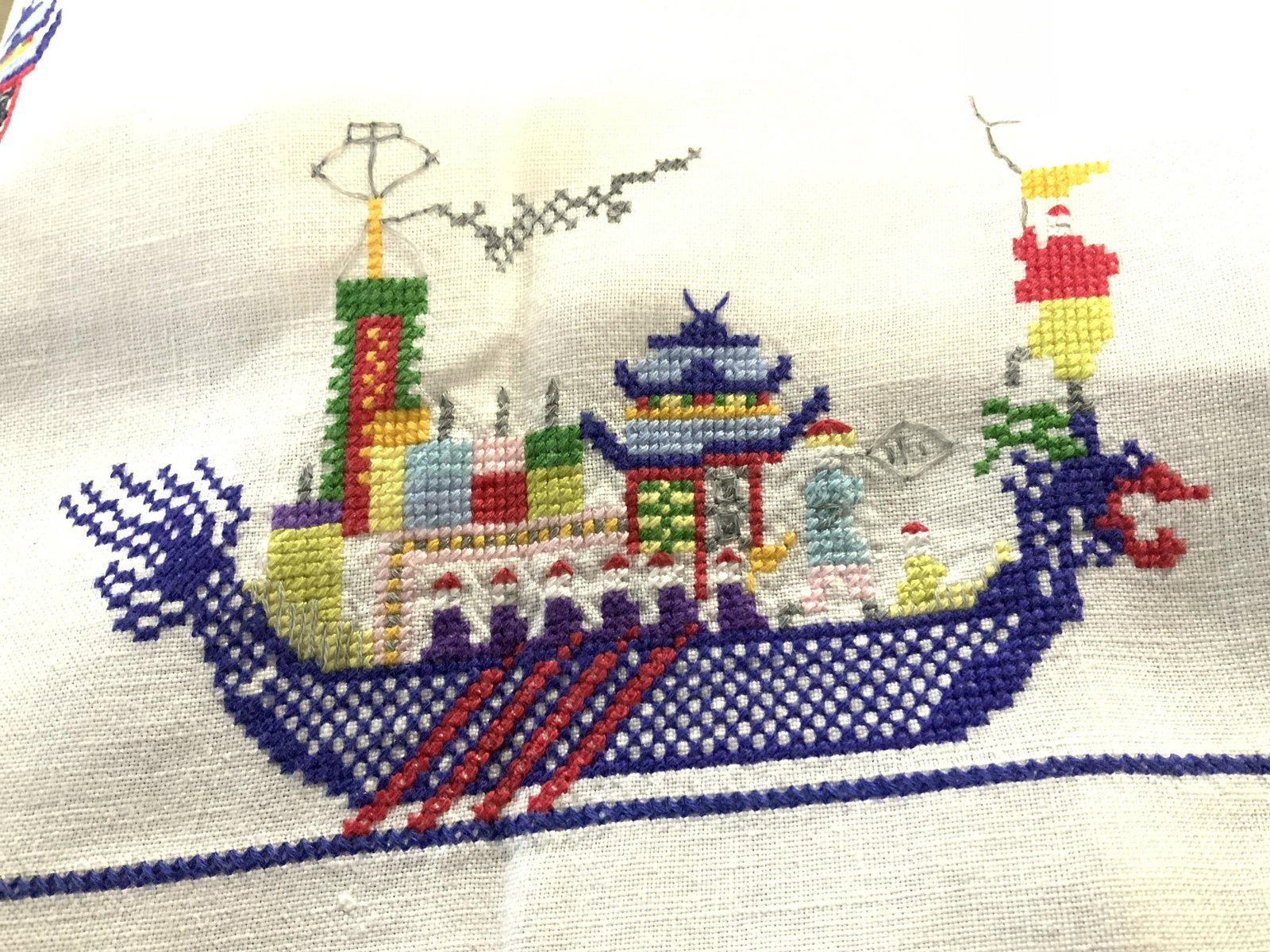 Collectible Hand Embroid. Linen Table Cloth set 8: Vintage white linen tablecloth, hand embroidered ( possibly) cross stitch, Asian Dragon Ship with thunder cloud border, matching napkins. Tablecloth measures 86 in. X 67 in. ( 7 ft. 2 in. X 5 ft 7 in.