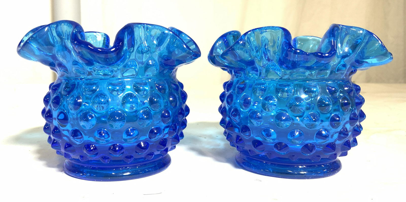 Pair Art Glass Candle Holder: Lot includes 2 candle holders. Each are blue toned & glass. Each have frilled rims & beveled dot detail. Candle holders measure approx 3 inches tall 4 inches wide. Candle holders, Art glass candle hol