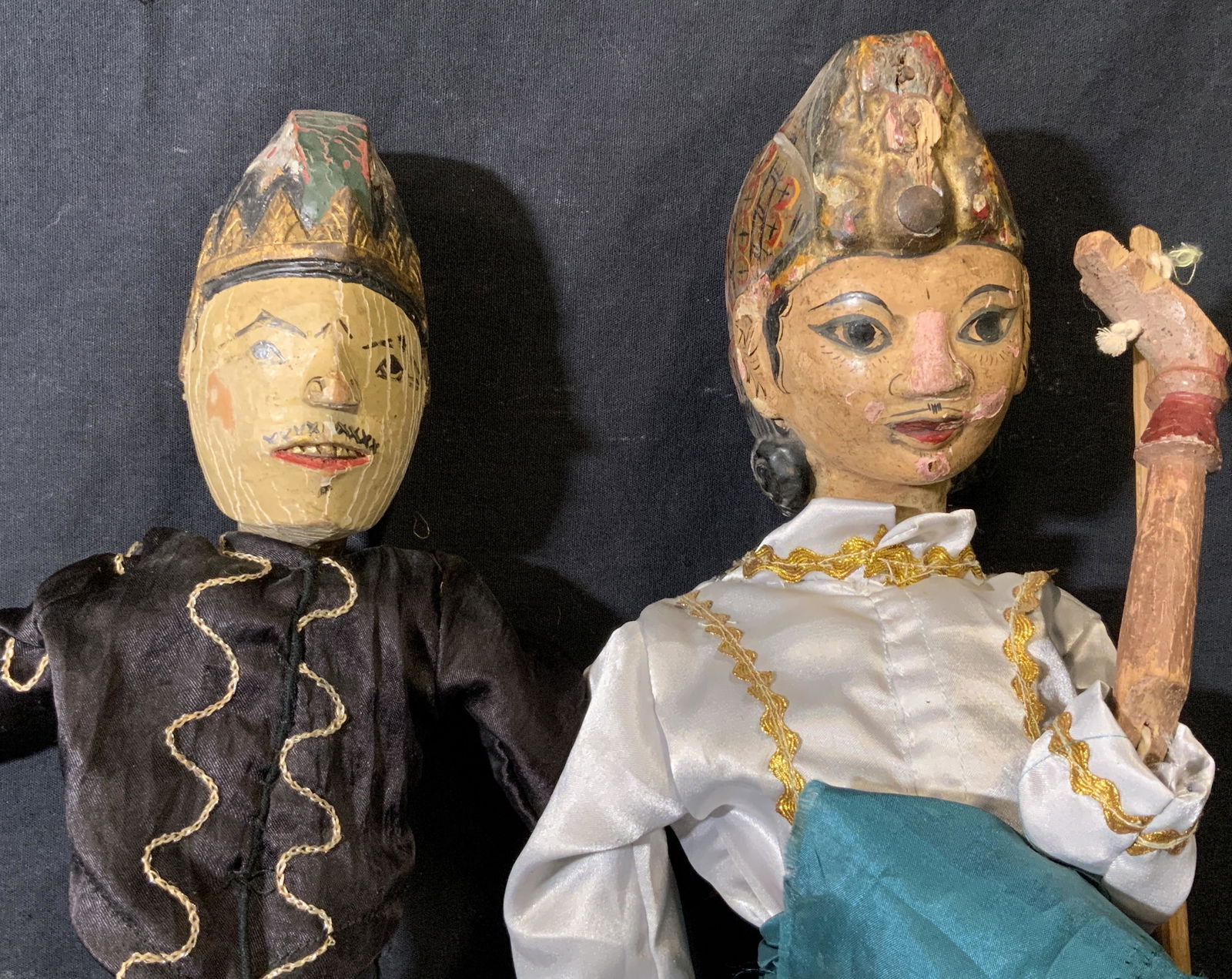 Pair Wayang Golek Indonesian Rod Puppets: Pair wayang Golek Indonesian rod puppets, each has a hand carved wooden head and arms all painted, both wear patterned yellow fabric clothes with white accents to one and black to the other, both meas