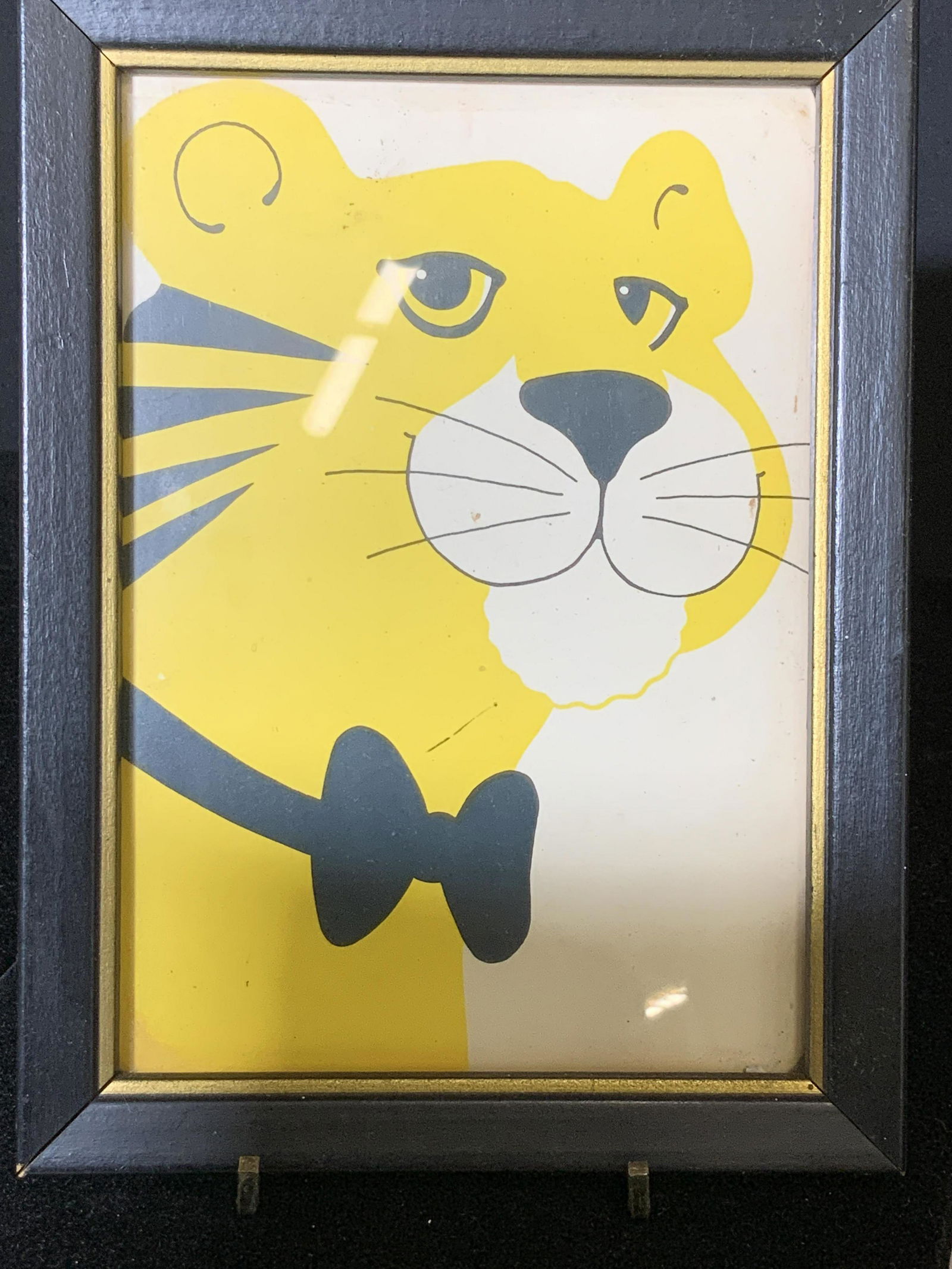 2 Framed Prints, Folk Art Cats: Happy Yellow Tiger Cat with black bow tie in black frame , 8 x 5.75 in. Tuxedo Cat sitting on books, signed print in black frame, 10 x 8 in. Both under glass. Cat Art, Works on Paper, Framed art, Cat