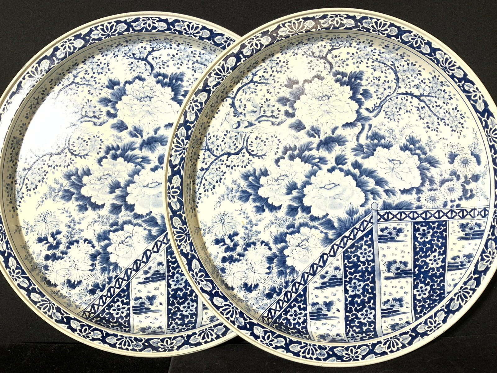 Pair Asian Toleware Round Trays after Ming Dynasty: Chrysanthemum design in collectible blue and white styled after Ming Dynasty Porcelain made famous during the 14th- 17 th c. Trays are lithographic reproductions and Hallmarked on backside with histor