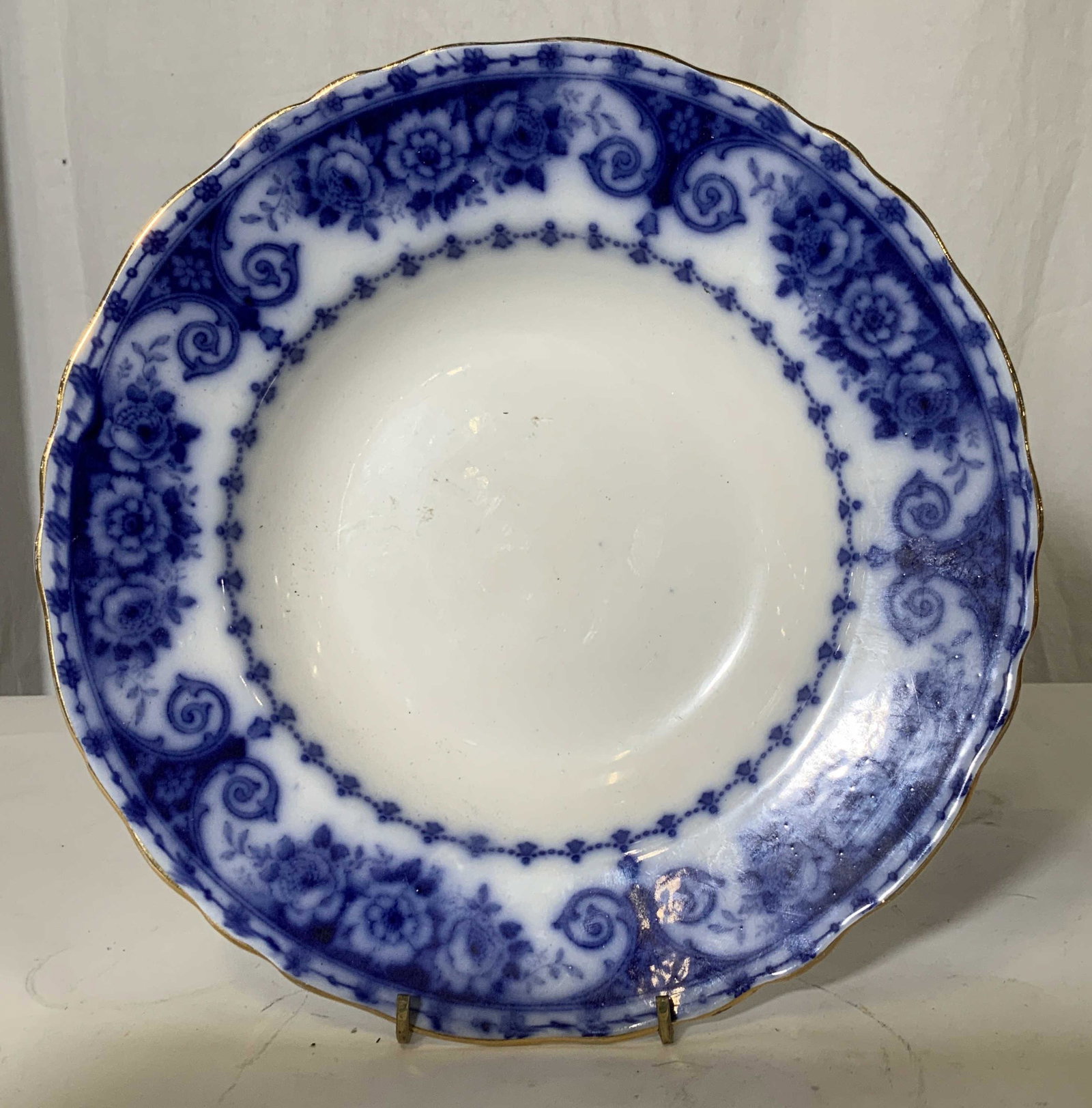 Blue & White Vintage Transfer Ware Ceramic Bowl: Gilt rim, blue scroll and floral transfer art on stark white porcelain bowl, Hallmarked on verso with swan, reads Osborne Trac 7. 10.5 in. Porcelain transfer ware bowl, blue and white transfer ware po