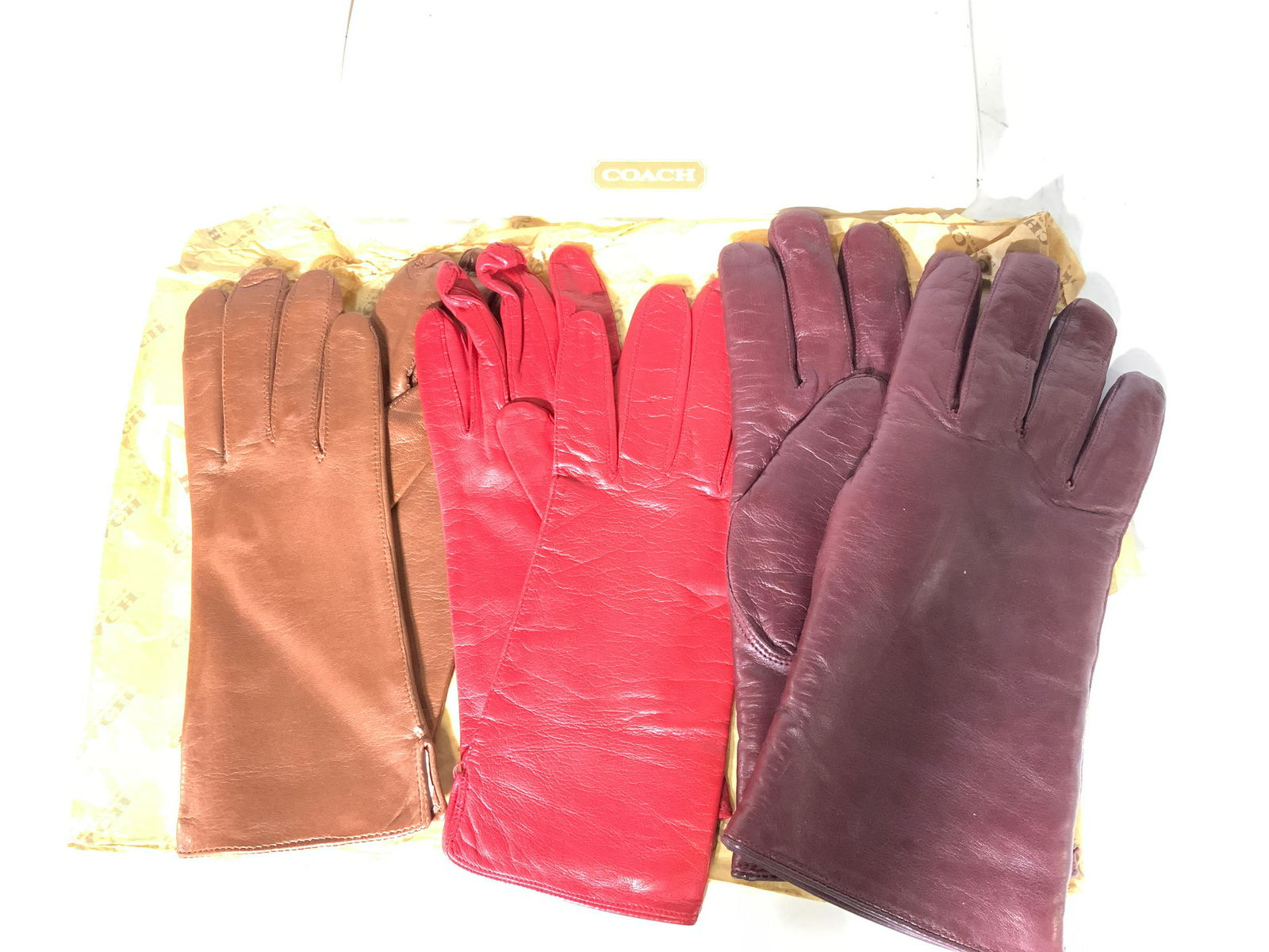 Lot 3 Luxury Leather COACH Gloves Org Box: COACH Gloves in red leather with silk lining , sz 8 NEVER WORN made in ITALY, COACH Carmel Leather gloves with silk lining sz 7 NEVER WORN, made in Hungary, COACH LEATHER AND SHEARLAND LINING , maroon