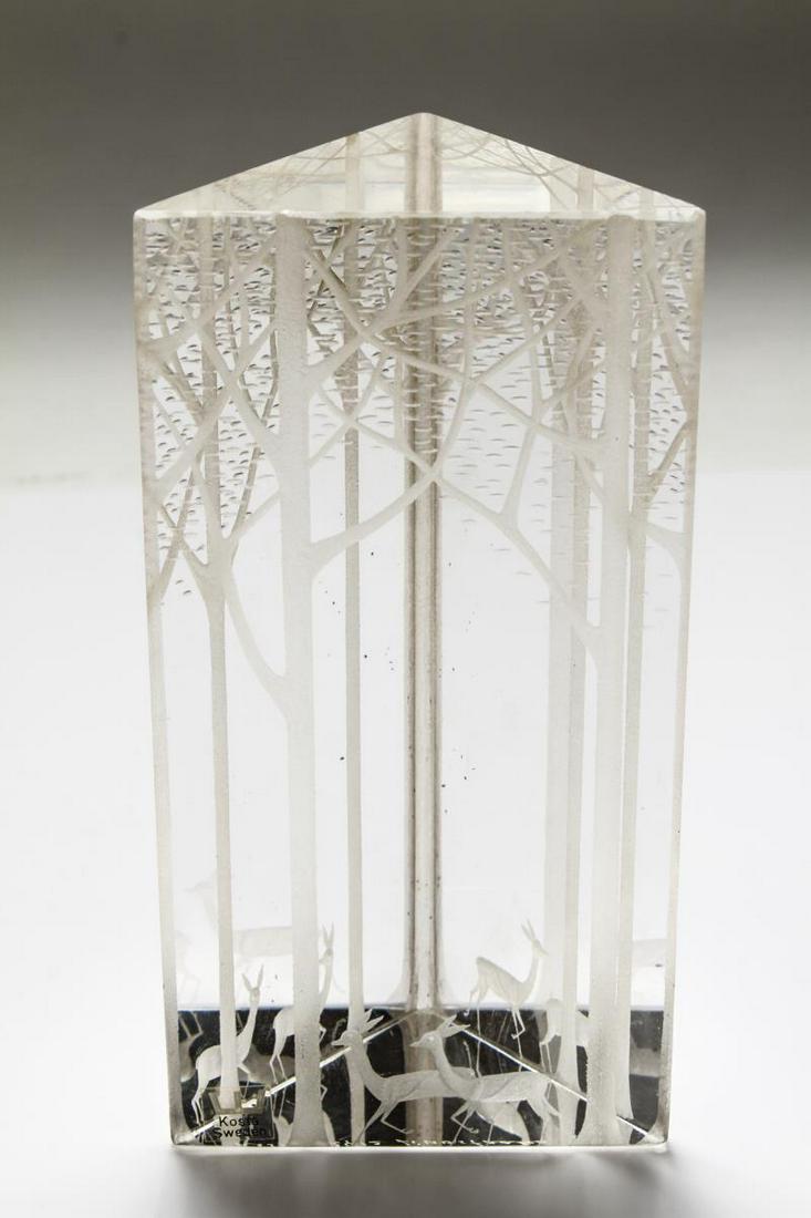 Kosta Boda Scandinavian Modern Prism: Kosta Boda colorless crystal "Deer in the Forest" triangular prism sculpture, one bottom edge with a "Kosta Sweden" label, the underside acid-etched "Kosta 92412 Lindstrand." 6.75" H. Tiny fleabite ch