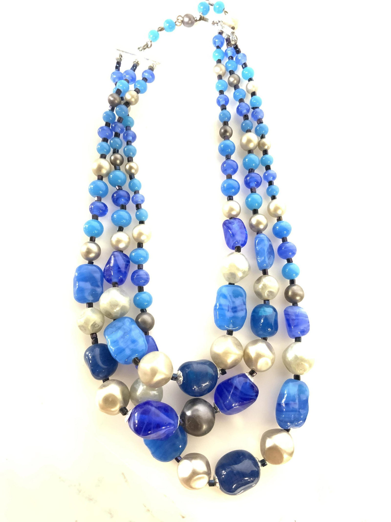 Organic Shape Cobalt Blue GLASS Choker Necklace: A modern style piece with hues of blue glass beads, cobalt & royal blue hues with silver toned beads interspersed. Three strand choker necklace, 15 in. at longest length, with backdrop faux pearl. Cla