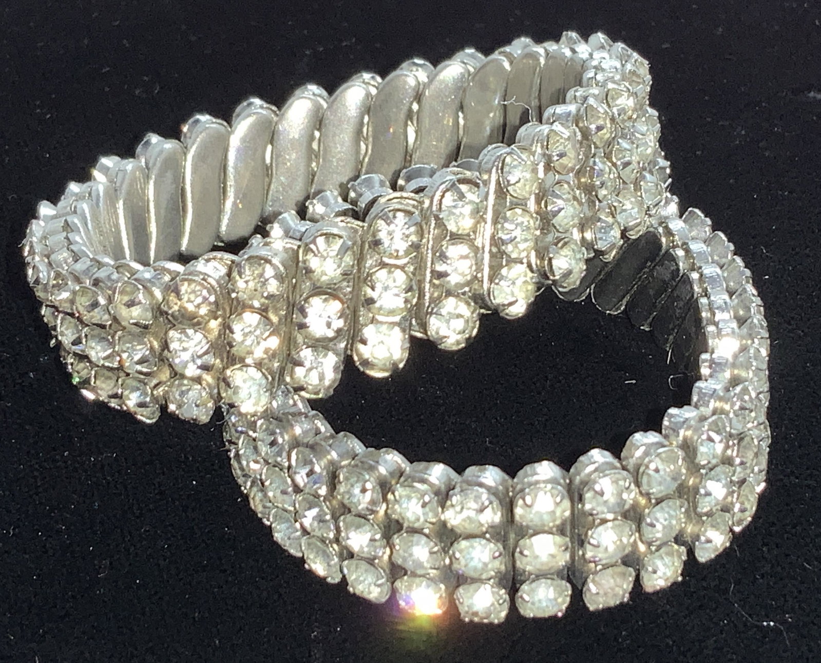 2-Retro Metal Stretch Rhinestone Bracelets: c. 1940s Rhinestone bracelets, set on metal stretch mechanism typical of jewelry made in that time. 1 bracelet w/ row of 3 rhinestones on the diagonal, all prong set, white metal. Stretches a little o