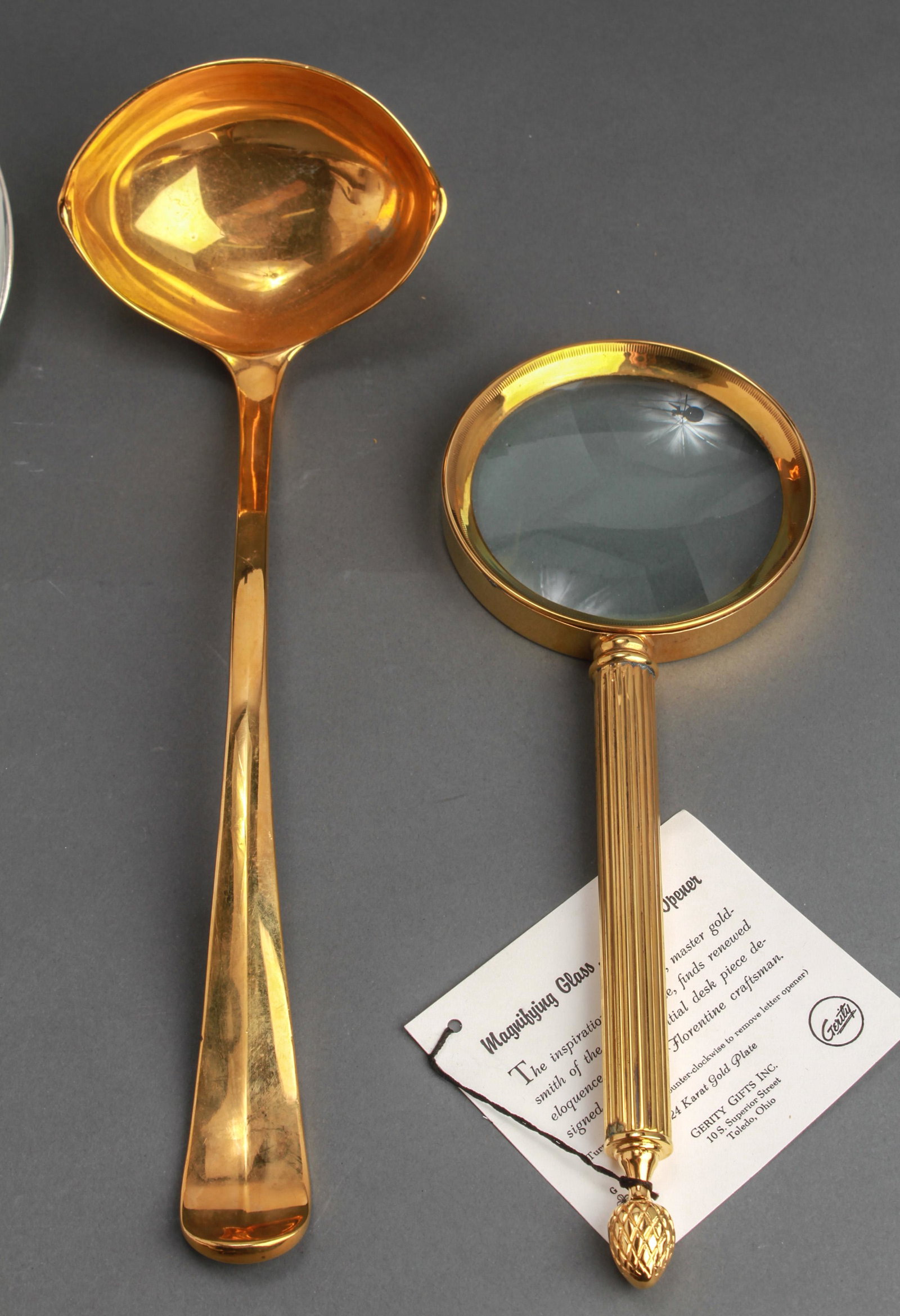 Gerity Gold & Silver Plate Servers & Magnifier, 5: Gerity servingware and accessories, group of five, comprising two silver-plate Georgian reproduction serving spoons, one silver-tone carving fork, one gold-plated ladle and one gold-plated magnifying 