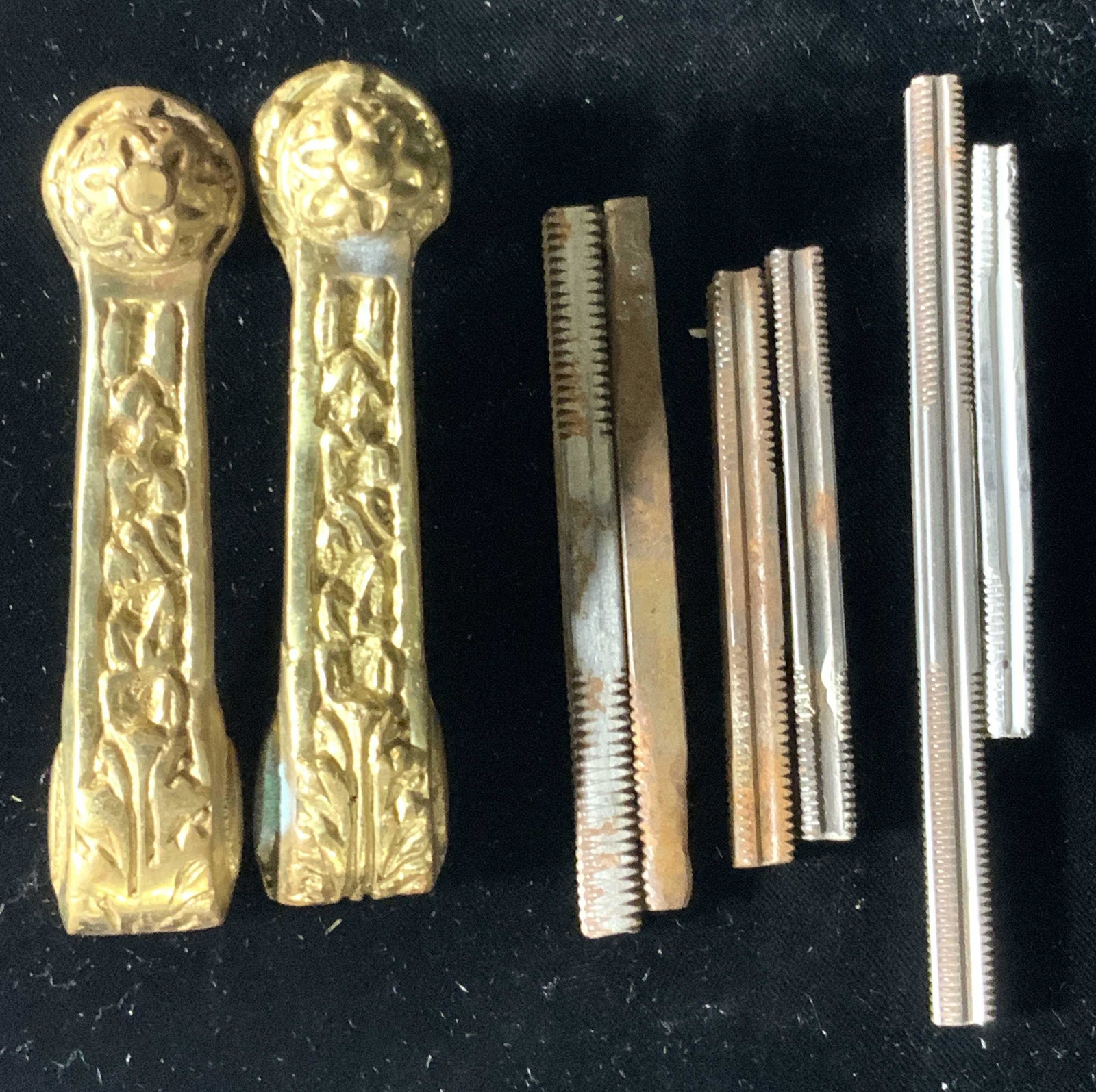 Lot 8 Doorhandles & Metal Accessories: Two gold tone metal door handles with embossed designs. Depicts florals and nature motifs. Matching pair. The metal accessories are crafted from silver tone metal, some rust and discoloration. Doorhan