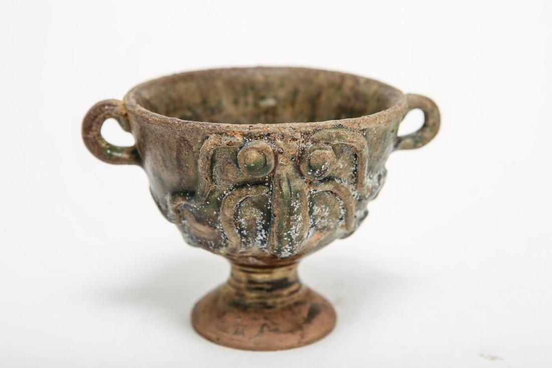 Chinese Double Handle Glazed Ceramic Cup with Face: Chinese glazed ceramic stem goblet with applied decoration and two small handles. 3.75" H x 5.25" diameter over handles. Wear and losses.