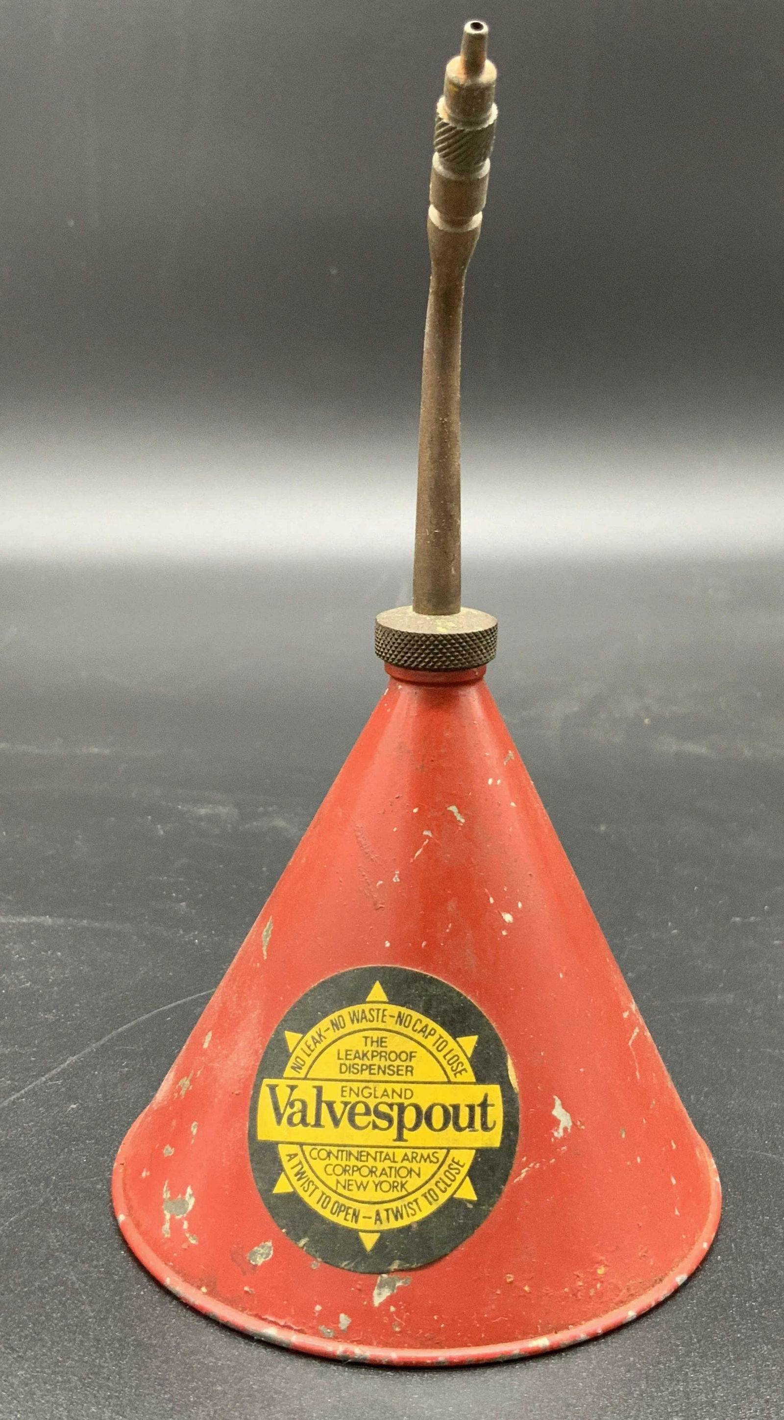 Vintage Collectible ENGLAND VALVESPOUT Oil Can: A vintage red metal oil can / oiler. Cone shaped. This piece was once used for oiling metalware. Frontside reads THE LEAKPROOF DISPENSER, ENGLAND VALVESPOUT, CONTINENTAL ARMS CORPORATION NEW YORK. App