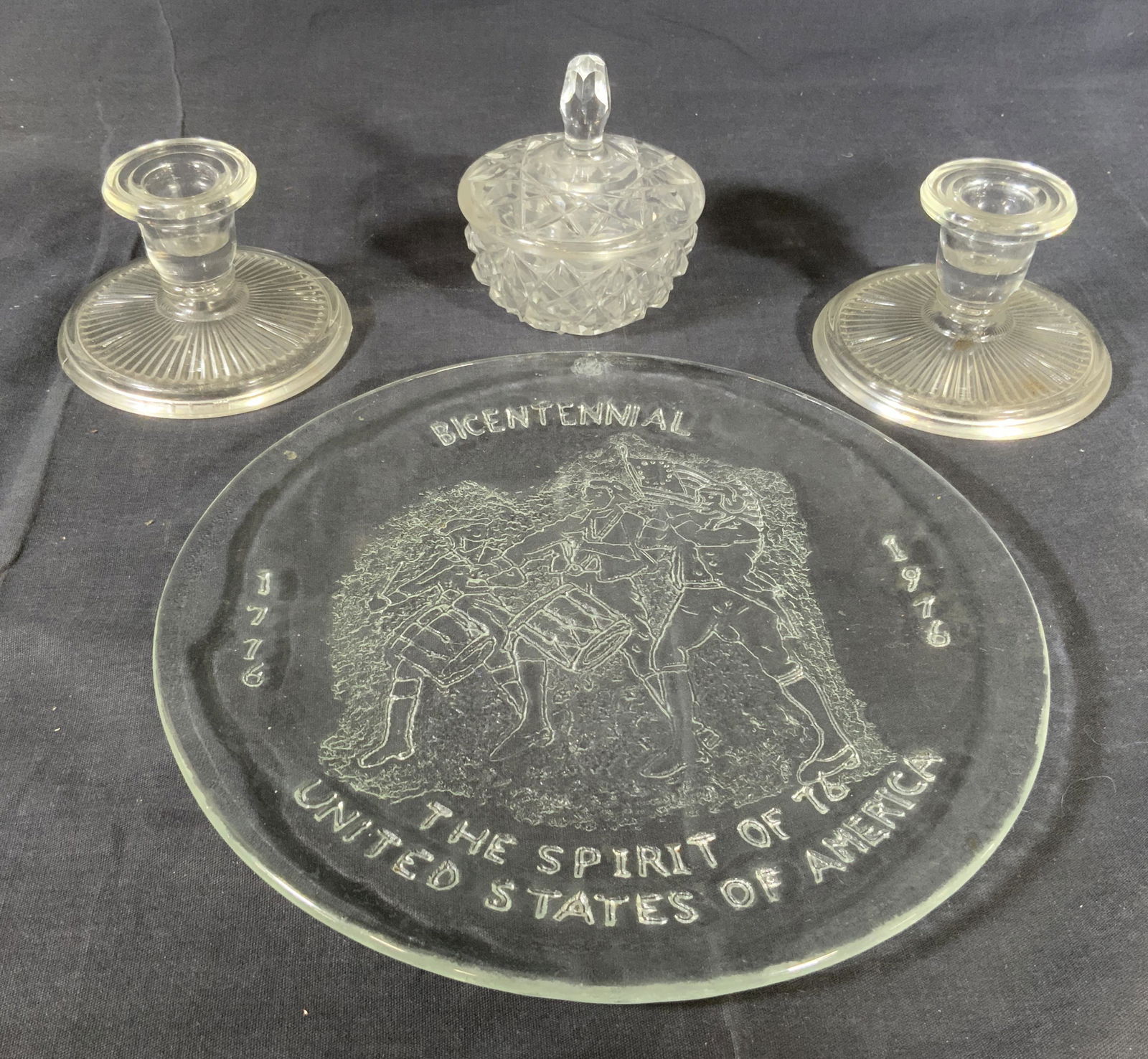 Lot 4 Glass Table Accessories: Lot 4 Glass Table Accessories, inscription to plate reads ‘Bicentennial 1776 1976 The Spirit of 76 United States of America’, plate measures 9 7/8 inches in diameter, candlesticks measure 2 5/8 in