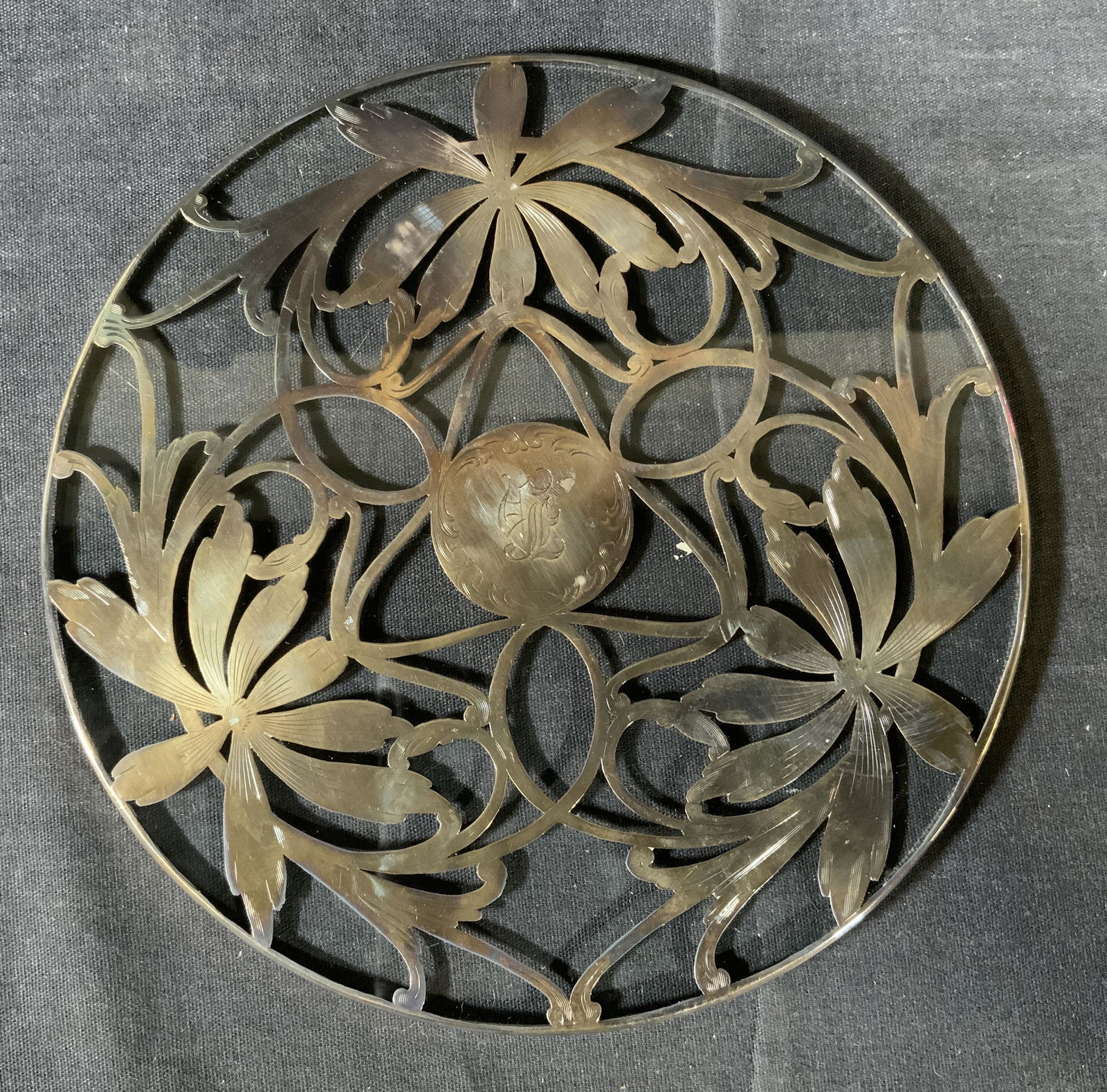 Glass Trivet with Sterling Silver Vegetal Elements: Glass Trivet with Sterling Silver Vegetal Elements, monogrammed letter illegible, inscription reads ‘Sterling 883’, measures 6 7/8 inches in diameter, surface wear to piece and tarnishing to metal