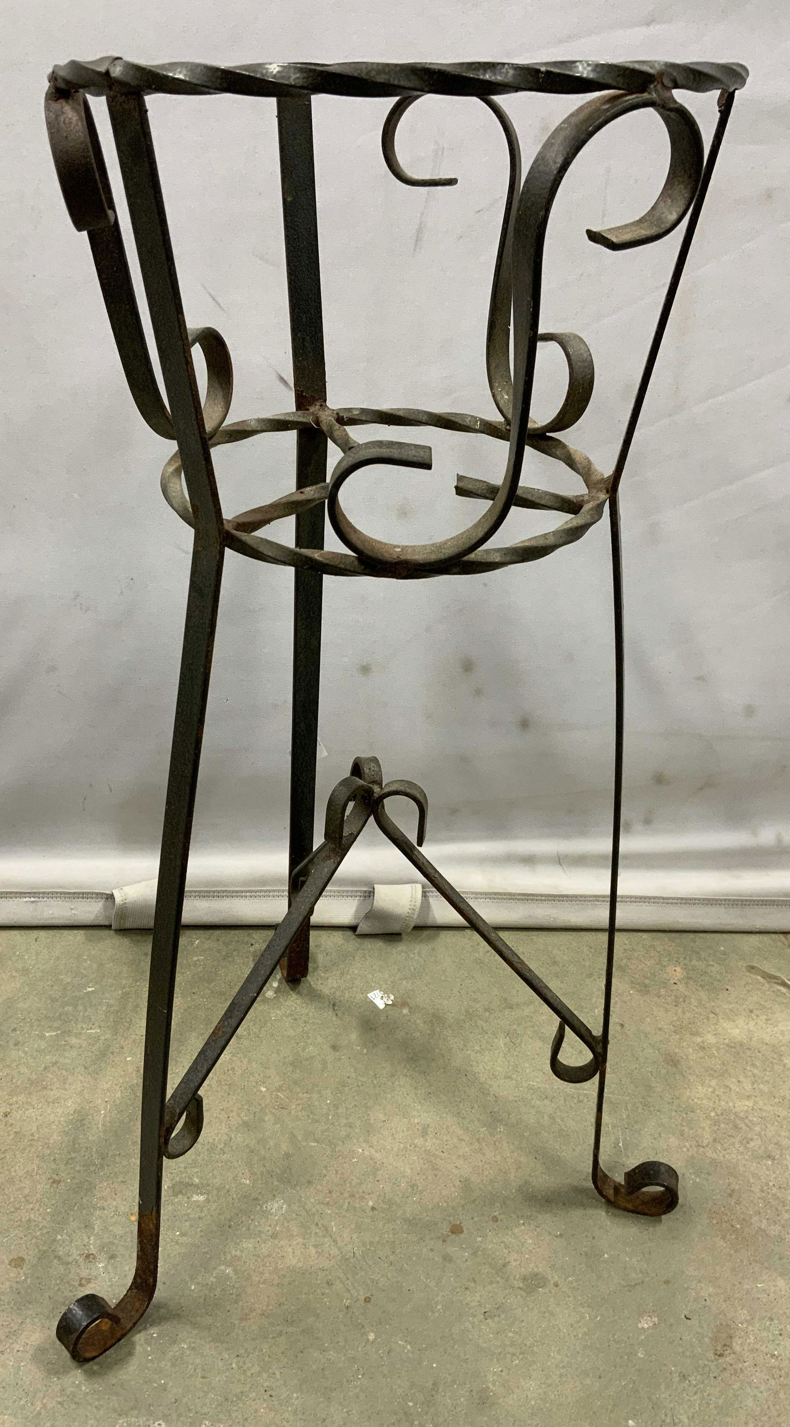 Wrought Iron Plant Stand: Wrought iron plant stand, possibly vintage. Wear is consistent with age and exposure. Measures approx 22.5 inches H x 13.5 inches W. Plant stand, planter, flower pot holder, outdoor furniture, decorat
