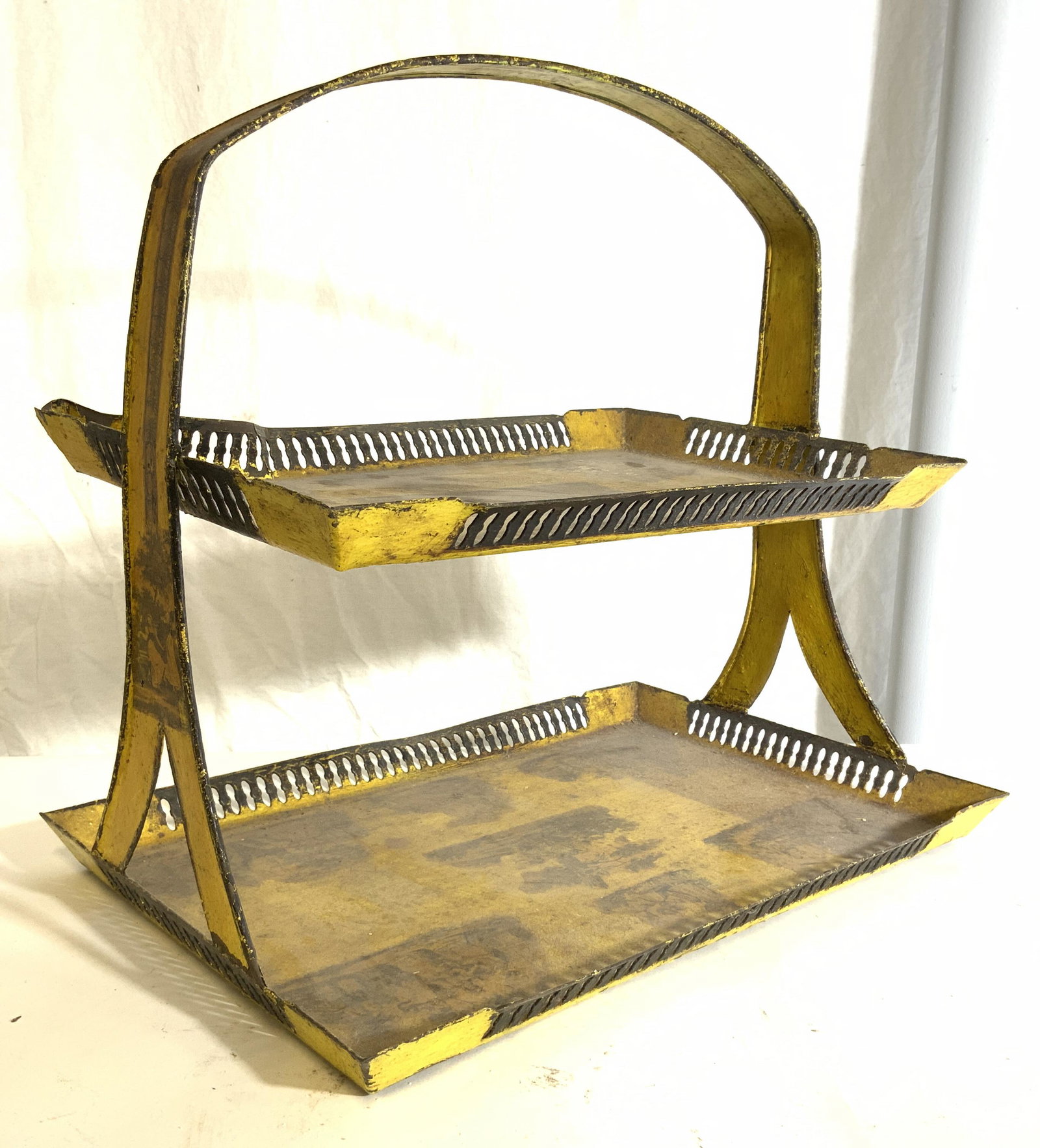 Vintage Metal Toleware 2 Tier Tray: Tray is yellow toned & metal, possibly Toleware. Piece has 2 tiers each with galleries with pierced detail. Tray has handle. Piece measures approx 15 inches tall 16.5 inches long 11 inches deep. Tray,