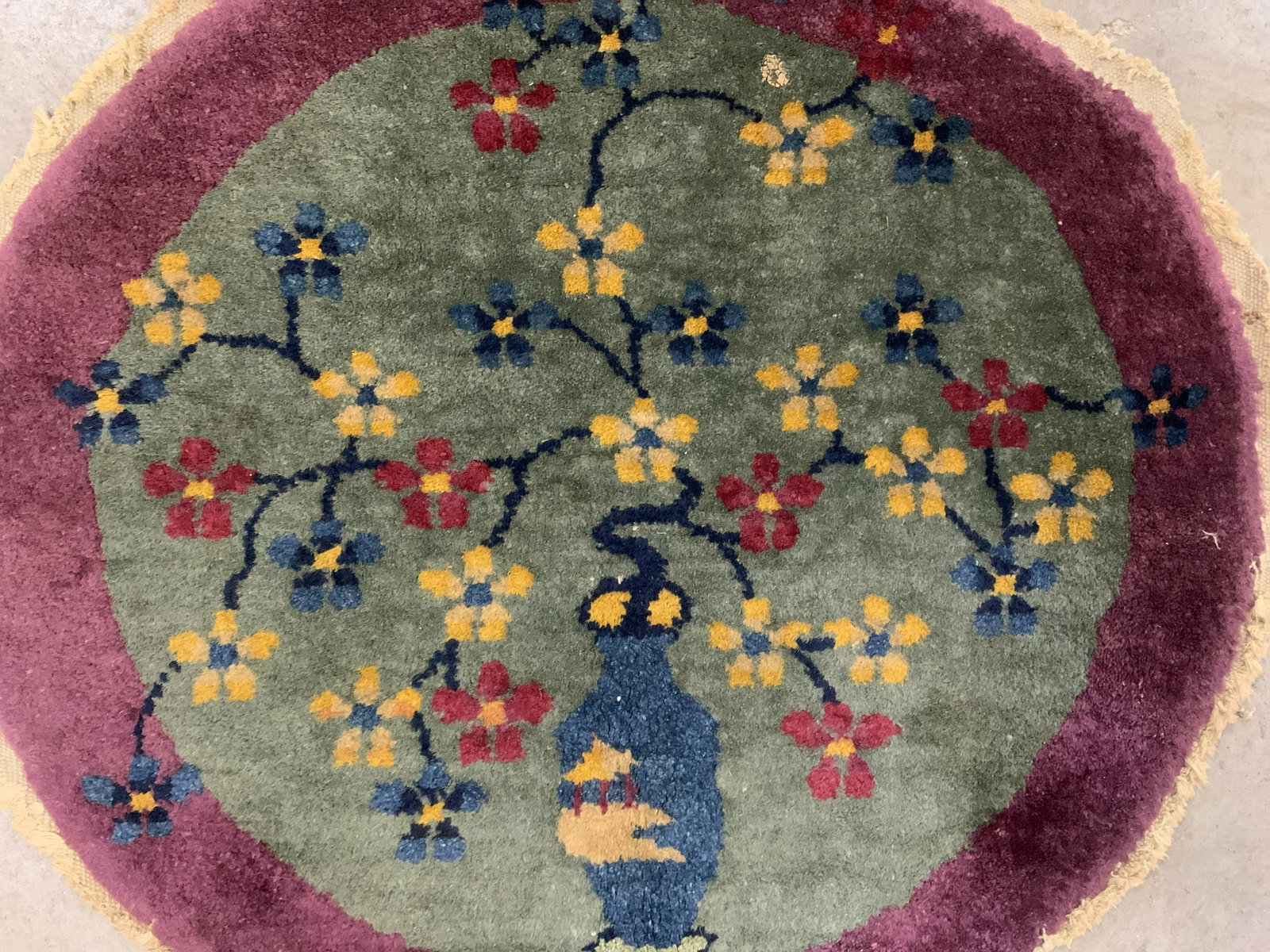 Vintage Handmade Chinese Art Deco Oval Wool Rug: Rug is vintage possibly antique. Piece is wool & handmade. Rug has multi toned floral, vase, vine & leaf detail. Outer area is purple toned. Rug, vintage rug, handmade rug, area rug, home furnishings,