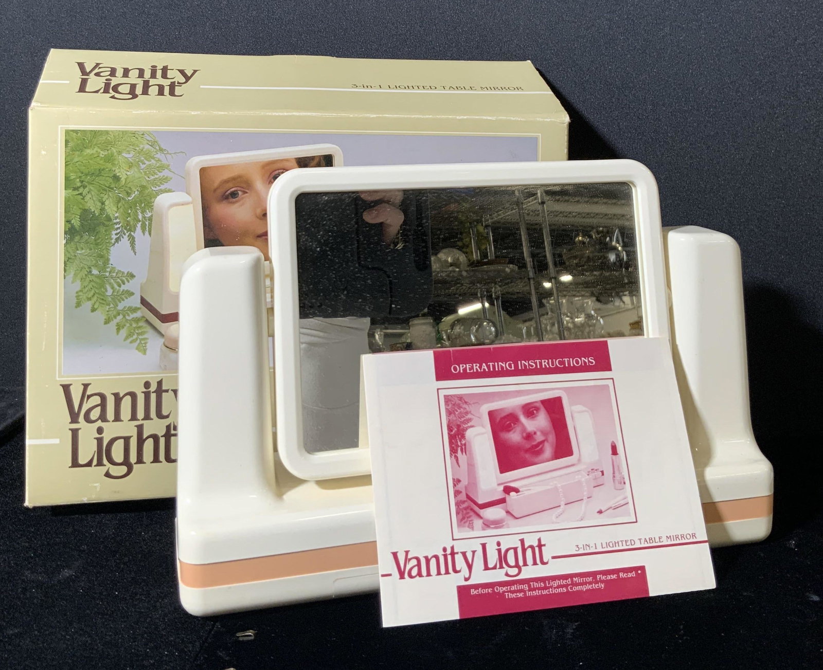 Vntg 3-In-1 Lighted Table Mirror W/ Original Box: A vintage vanity mirror that comes with it’s original box. The box reads 3-IN-1 LIGHTED TABLE MIRROR, VANITY LIGHT. The piece appears to have not been used. The instruction pamphlet comes in the box