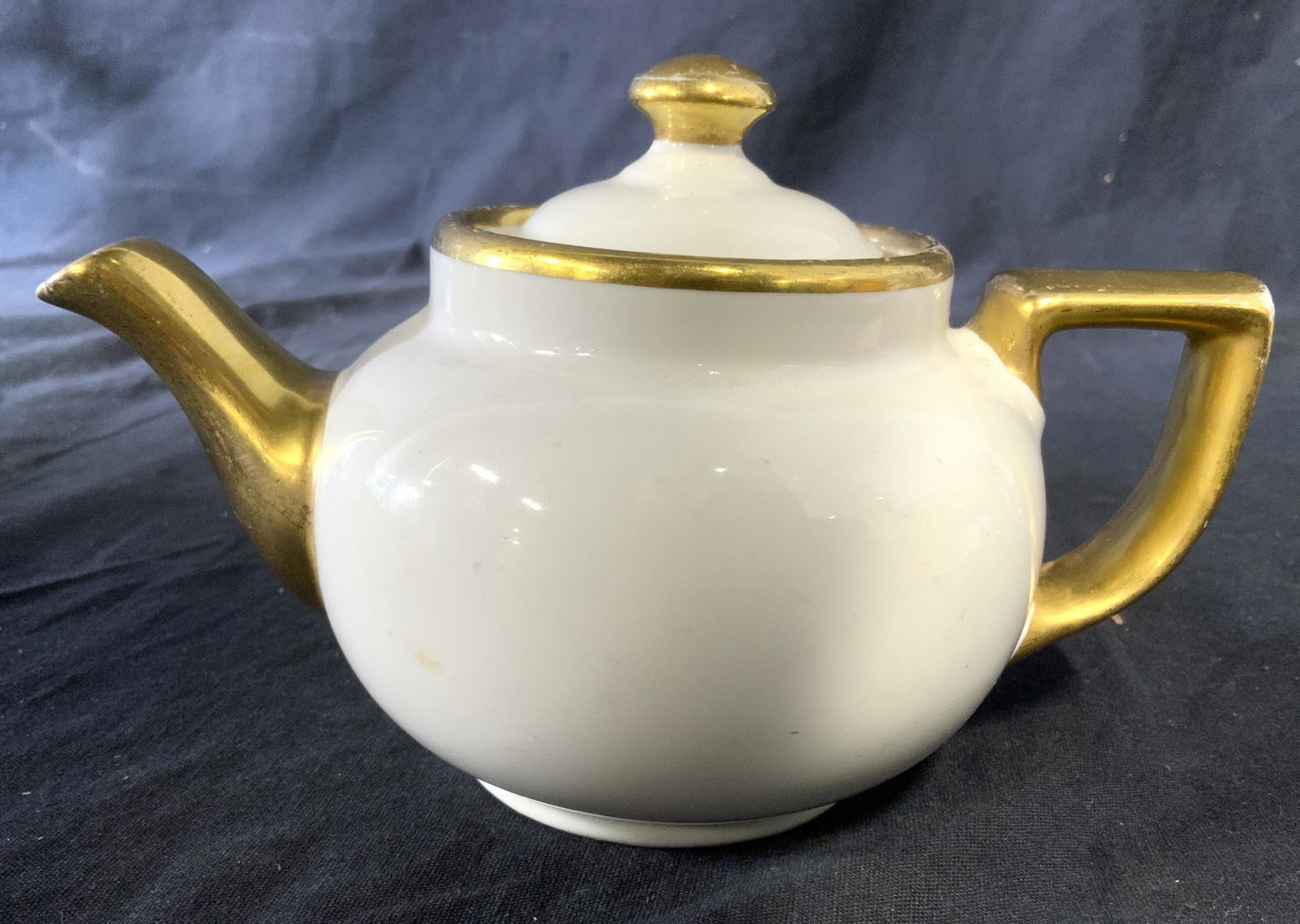 Vintage HALL CHINA COMPANY Tea Kettle: Vintage HALL CHINA COMPANY tea kettle. Spout, handle, and lid are colored with gilt paint. Underside is trademarked and reads as HALL MADE IN USA. Measures approx 4.25 inches H, and 7 inches W. Wear i