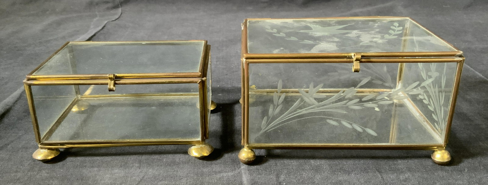 Lot 2 Brass & Glass Keepsake Display Boxes: Lot 2 Brass & Glass Shadow Boxes, no apparent inscriptions or marks, smaller box measures 2 1/2 inches tall x 4 5/8 inches at widest point, larger box measures 3 1/8 inches tall x 5 1/4 inches at wide
