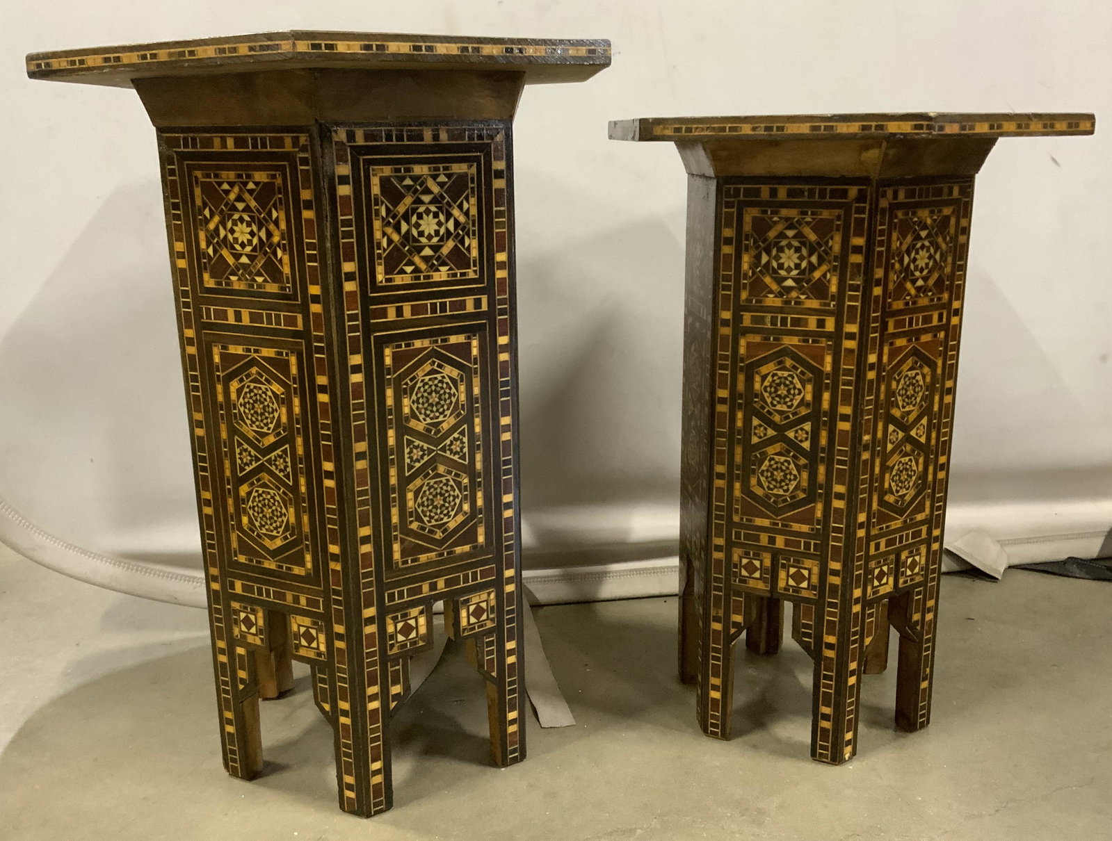 Pair Vintage Mosaic Wooden Side Tables: Pair of vintage, hexagonal side tables. Decorated with multi toned in.aid wood detailing. Appears to be hand made. Largest measures approx 18.5 inches H, and 14.5 inches w. Wear is consistent with age