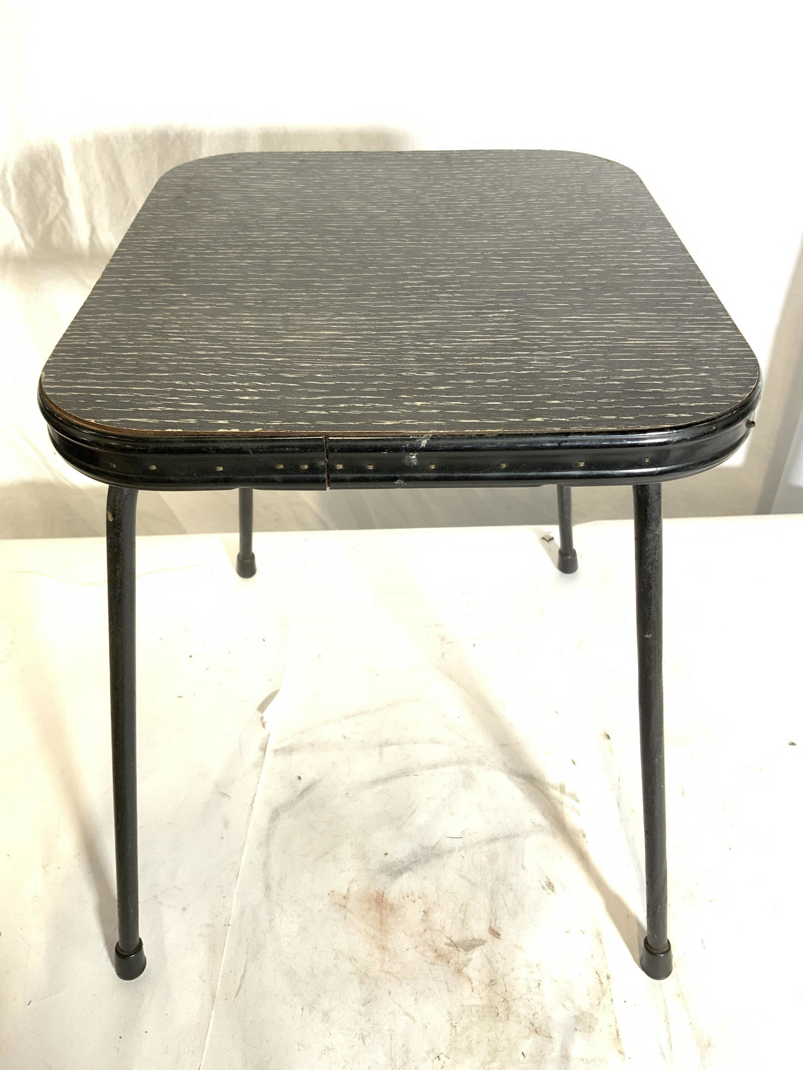 Vintage Metal Foot stool Kitchen Stool: Kitchen stool is black toned and metal. Piece had 4 legs each with with black, toned capped rubber feet. Piece measures approx 12 inches tall & deep 10 inches wide. Stool, foot stool, kitchen stool, m