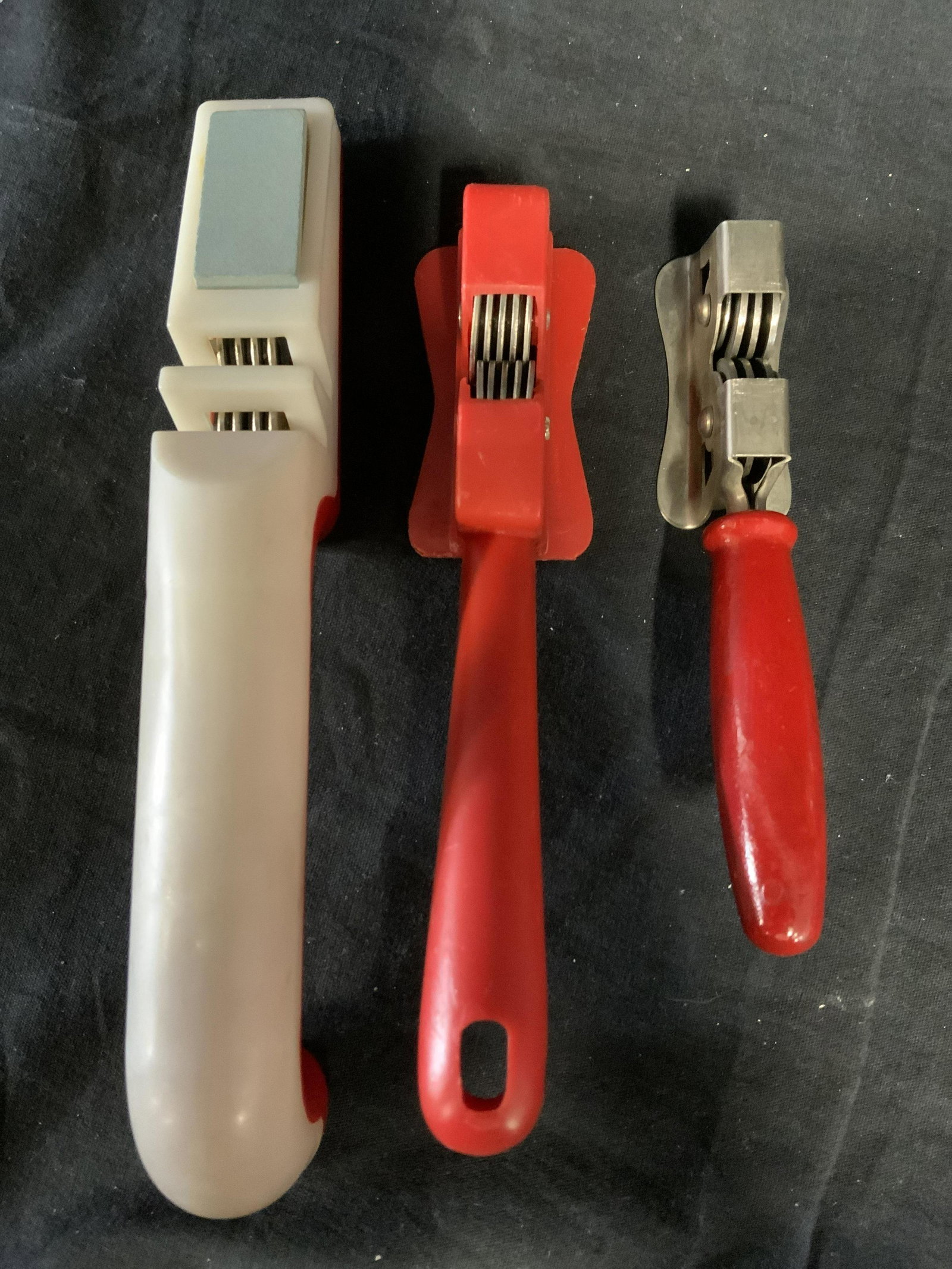 Lot 3 Vintage Knife Sharpeners: Lot of three vintage knife sharpeners. Two of the sharpeners can be affixed to a nail or hook. One of the sharpeners is equipped with a whetstone. Largest measures approx 8.75 inches long. From Collec