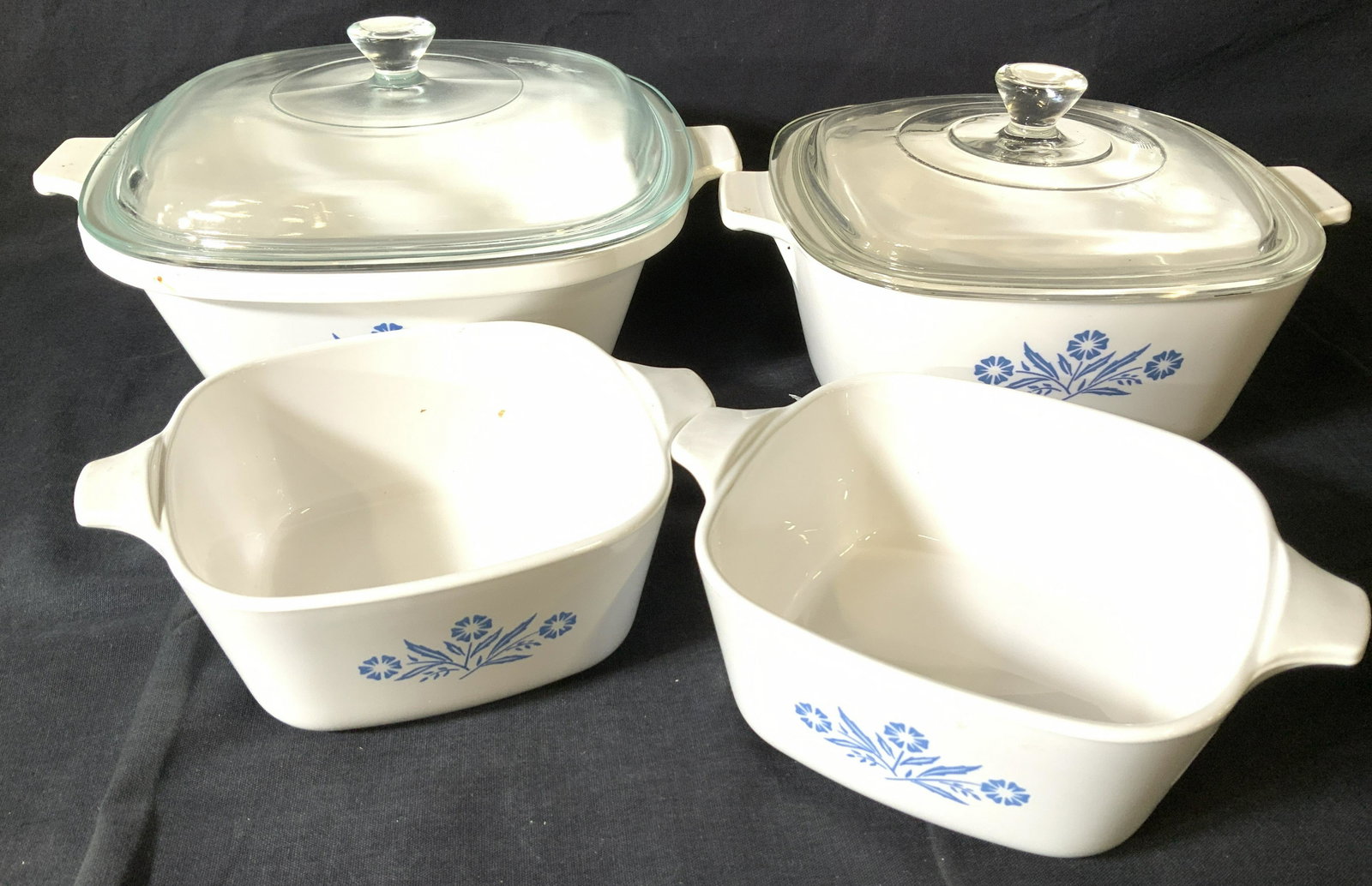 Collectible Corning Ware Lot 4: Oven to table CORNING WARE, vintage with blue flower print. Two small cookware with no lids, measure app 5.25 x 5 (for the lid), medium and larger cookware with fitted lids, larger measures 3.25 in de