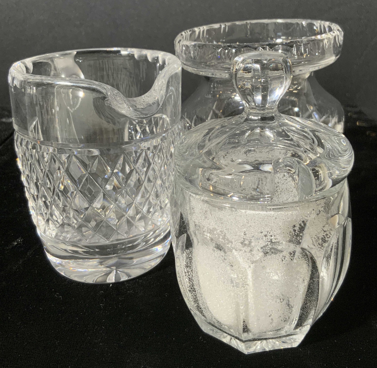 Lot 3 Cut Crystal & Glass Tabletop Vessels: Three pieces of tableware that can be used for holding sugar, creamer, flowers, and more. The lidded vessel is crafted from thick walled glass. There is some residue within the interior. The two other