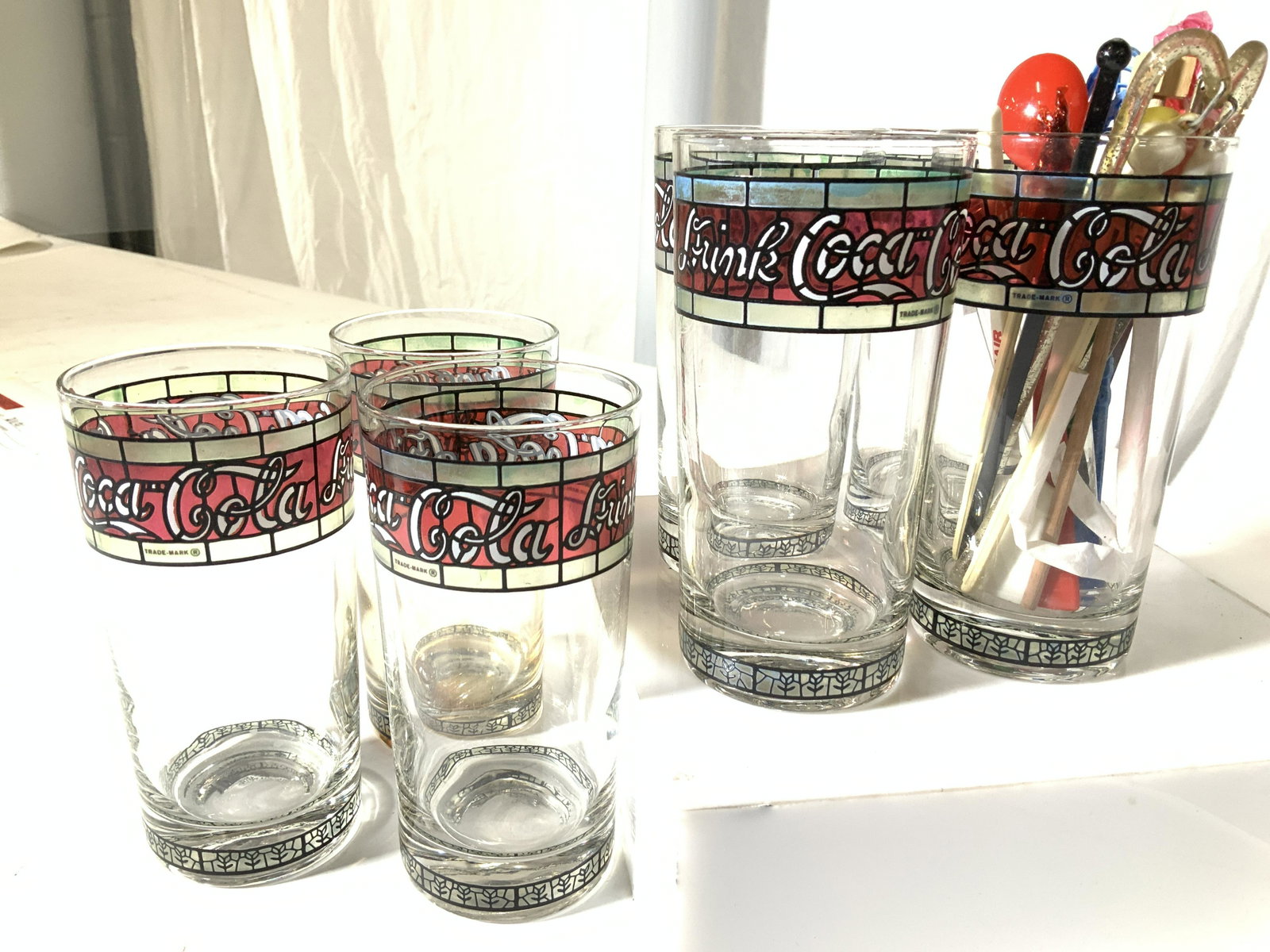 Set 7 Vintage Stencil COCA-COLA Beverage Glasses: Reminiscent of the early 1980s ‘Drink Coca Cola’ campaign are these Coca-Cola tumblers with a stained glass style stencil, trademarked. Hard to find vintage Coca Cola memorabilia. 5.5 in ht, 2.5 i