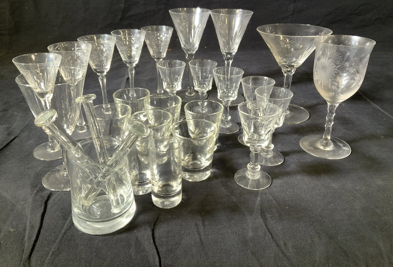 Group 28 Vntg Crystal & Glass Aperitif & Barware: Etched Crystal Cordial Stemware, Martini, Wine, aperitif stemware. Shot glasses , glass mixers and glass pourer. 1 middle size aperitif glass with rim chip. Either clear Crystal or Laurel and Star etc