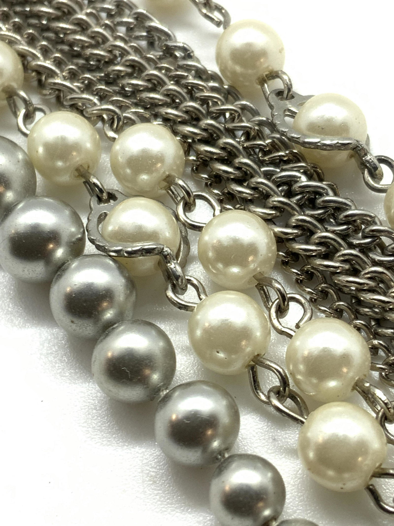 Lot 2 Pearlescent & Metallic Beaded Necklaces: Two necklaces that can be worn together or separately. One piece is comprised of graduated silver tone metallic beads. Choker style and secures with a fishhook clasp closure. Approx. Length 14 in. The