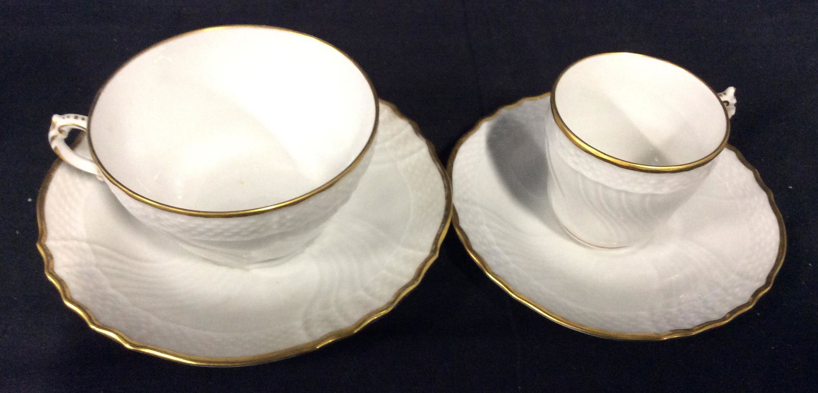R. GINORI WT. Porcelain Demitasse & Tea Set ITALY: 14 pcs total. 7 place settings, 2 with tea cups, 5 with Demitasse cups. Repoussé Basket Weave Border, Gilt rim, all white, Lrg saucer 5 in. Tea cup total width 4 in. , 2.25 in ht. All pcs Hallmarked