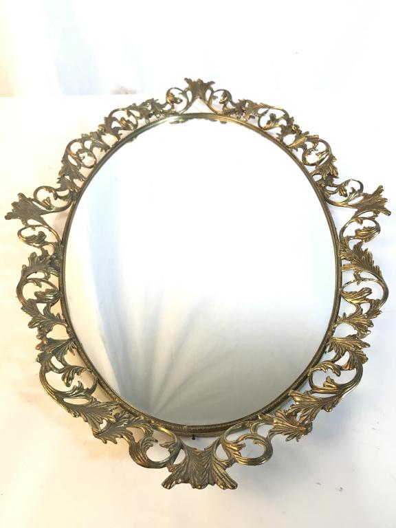 Vanity Mirror Tray W Gold Toned Frame: Piece is oval shaped. Contains gold toned frame with ornate detail. Measures approx 26 inches long 16 inches wide. vanity tray, dresser tray, home accent and decor, 6