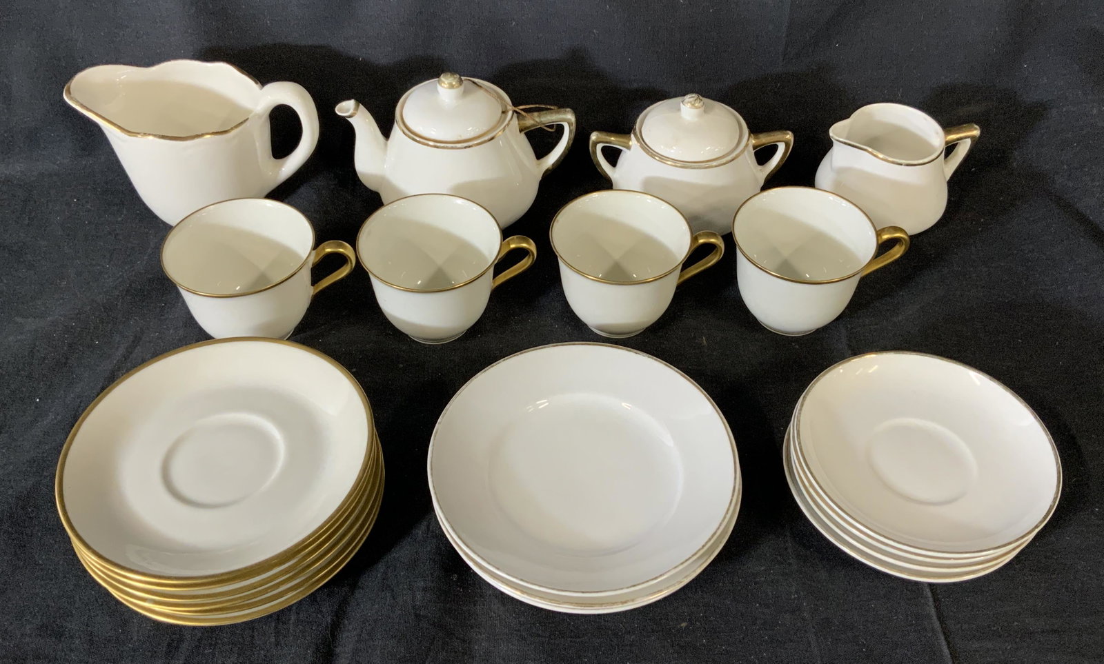 Lot 21 Rich & Fischer and Meito Mixed Tea Service: Lot 21 Porcelain Teacups, Saucers, Teapot, stamp to base of teacups reads ‘Rich & Fischer 467 5th Ave New York’, stamp to base of second largest saucers reads ‘France Charles Ahrenfeldt Limoges 