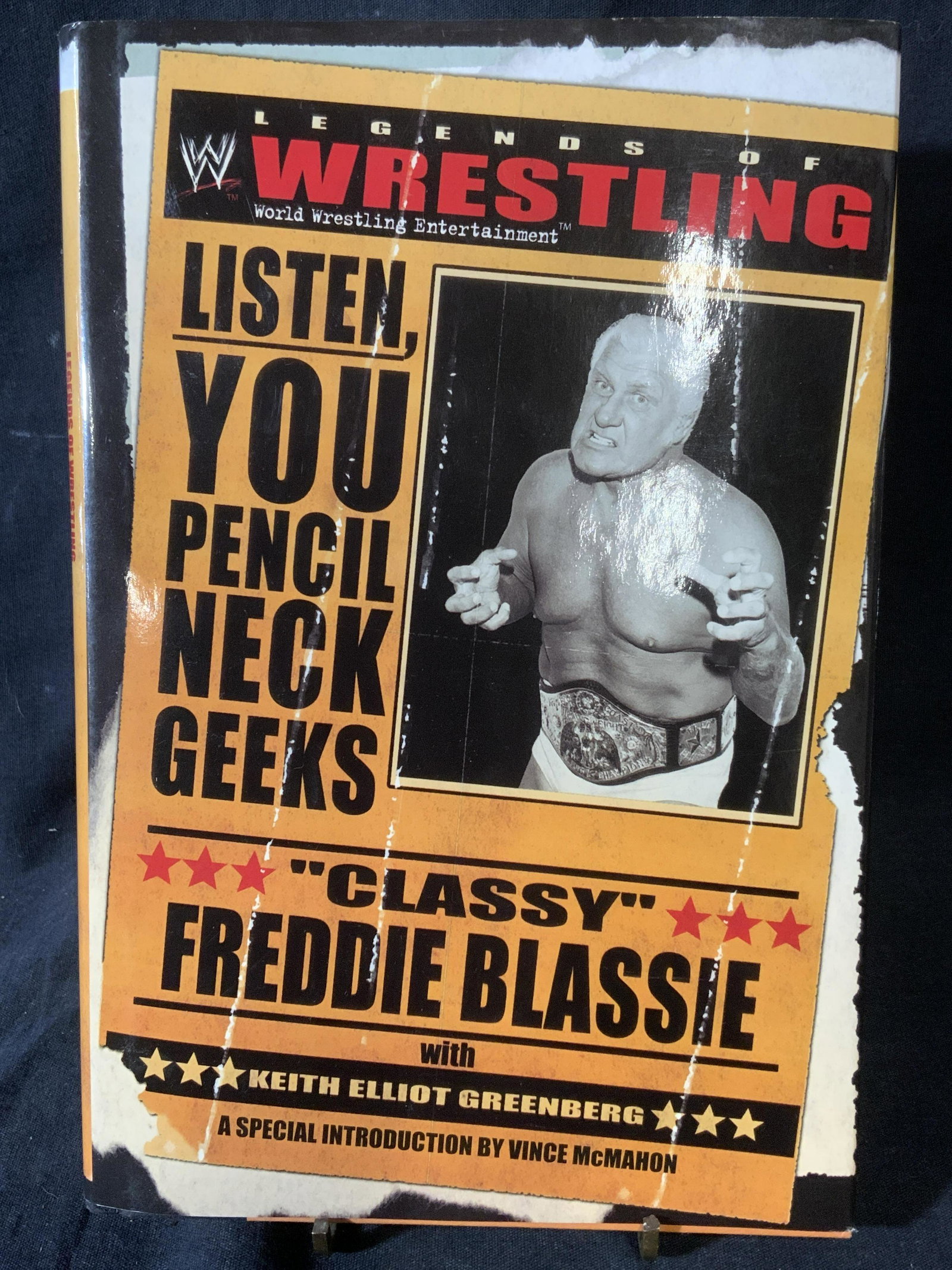 Signed HHH & STEPHANIE MCMAHON to REGIS PHILBIN: Signed copy of LISTEN, YOU PENCIL NECK GEEKS, CLASSY FREDDIE BLASSIE, WITH ELLIOT GREENBERG, an autobiography detailing the career of professional wrestler FREDDIE BLASSIE. Inside is signed by profess