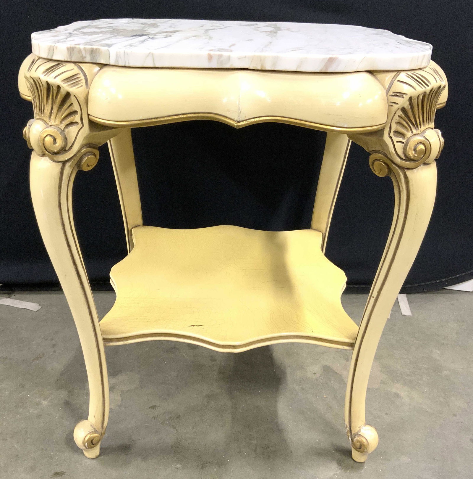 Pair Louis XV Marble Top Carved Wooden Side Tables: Side tables have Louis XV style. Piece is cream with gold leaf areas. Piece has slate & white toned marble top. Legs have board stretcher in between. Feet have curled structures. Corners near top have