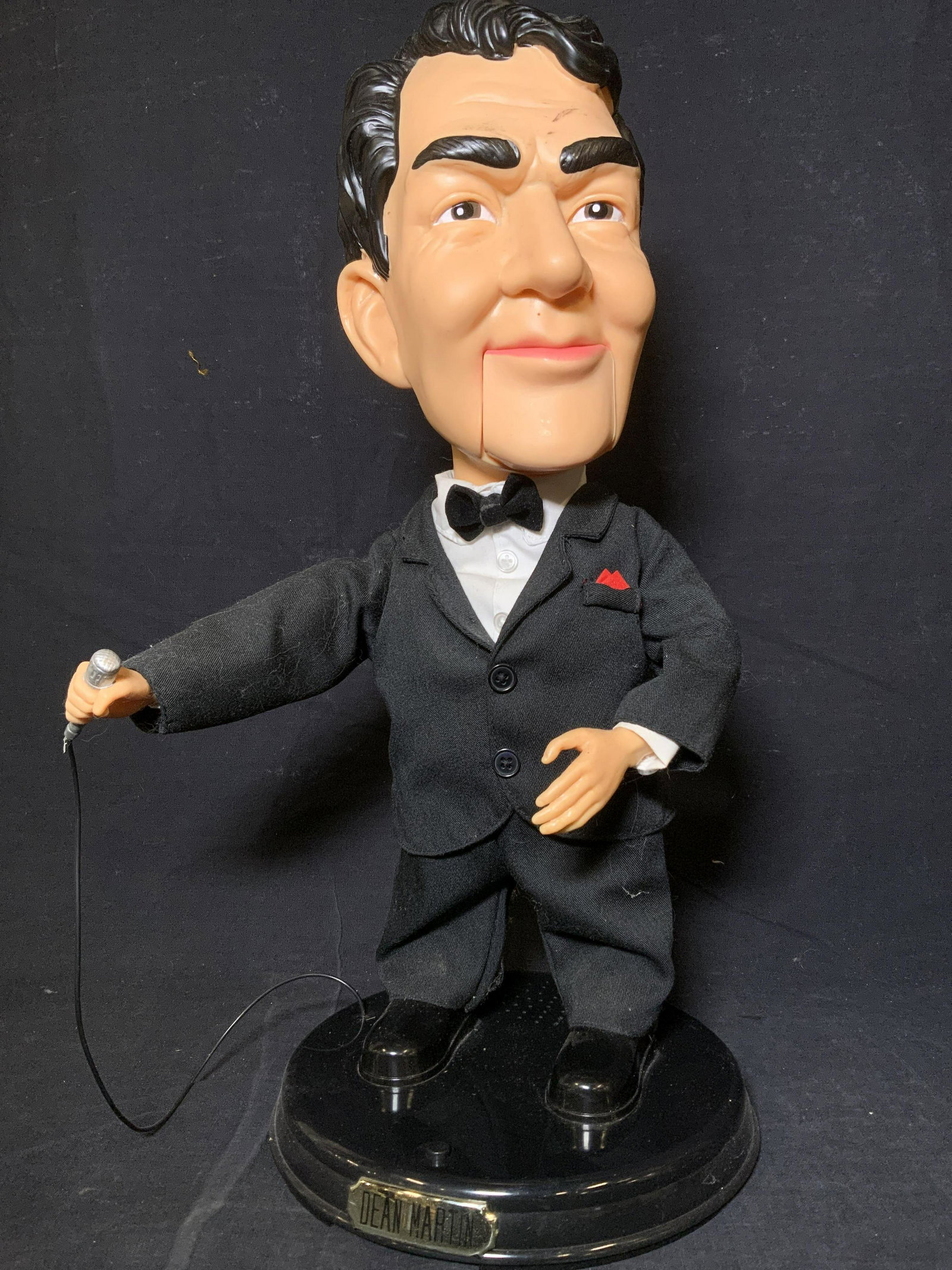 Collectible DEAN MARTIN Animatronic Figure: Dean Martin animatronic figure. Figure is mounted to a plastic base, base reads as DEAN MARTIN. Depicts a stylized Dean Martin holding a mic, and wearing a tuxedo. Measures approx 17.75 inches H, and 