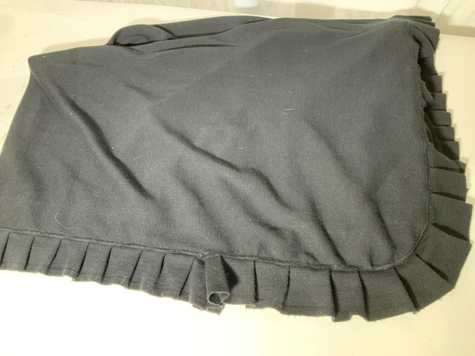Joy Philbin Black Wool Ruffle Shawl: Part of Joy Philibin’s Personal collection. An all black wool shawl, oval shape with ruffle edge. Designer tag cut off. Measures 42 x 63 in. This item was generously donated by Regis Philbin’s fam
