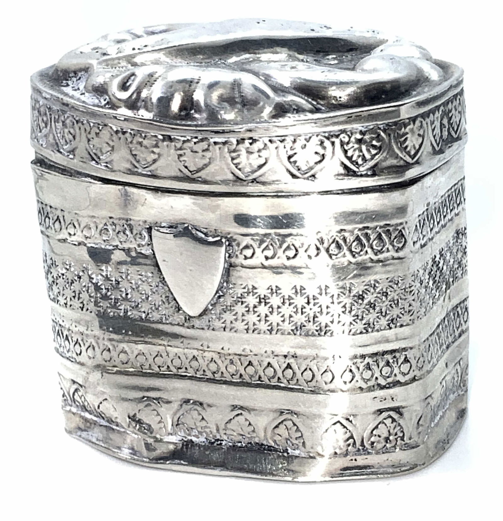 Antique Dutch Sterling Silver Hallmarked Pill Box: An antique (circa 1876) sterling silver pill box. The base and lid are connected via hinge hardware. The exterior detailing features intricately etched patterned band designs. The lid is covered entir