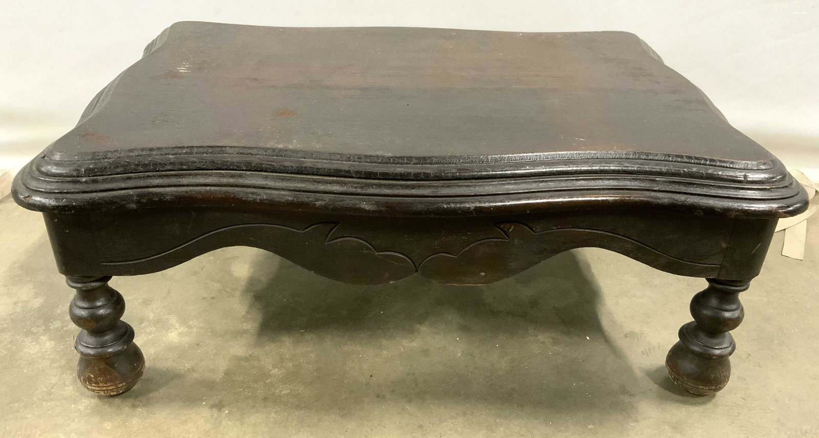 Vintage Low Carved Wooden Tea Table: Table is vintage & wooden. Piece is possibly hand crafted. Contains carved wooden feet. Table has low height. Piece measures approx 26 inches long 18 inches deep 10 inches tall. Tea table, wooden tea 