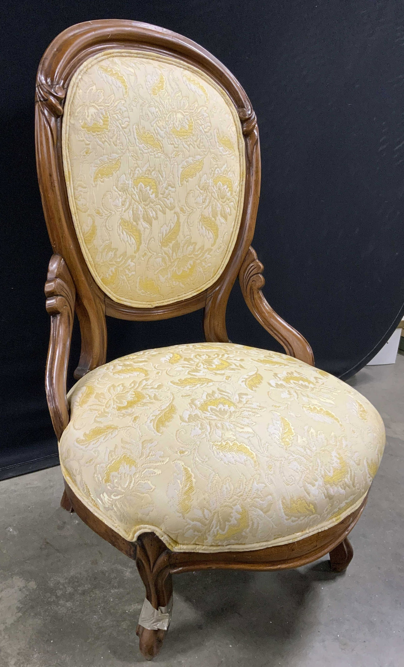 Vintage Low French Provincial Style Chair: Chair is vintage possibly antique. Piece has carved wooden frame with detail. Upholstery is gold toned with floral & leaf detail. Edges of upholstery have double welting. Chair is possibly custom made
