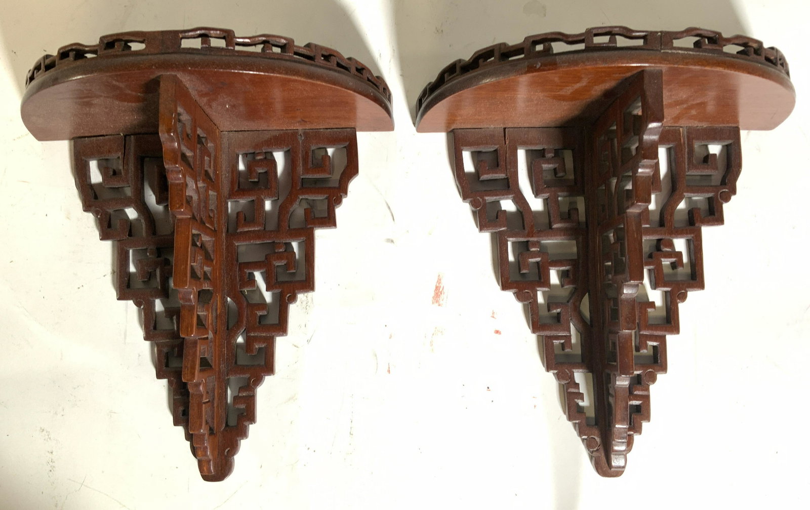 REGIS PHILBIN Pr Carved Wall Mount Shelves: Lot includes 2 wall mount shelves. Each are wooden with carved detail. Top of each piece has carved wooden gallery. Shelf surface has half circle shape. Each piece measures approx 10 inches tall 9.5 i