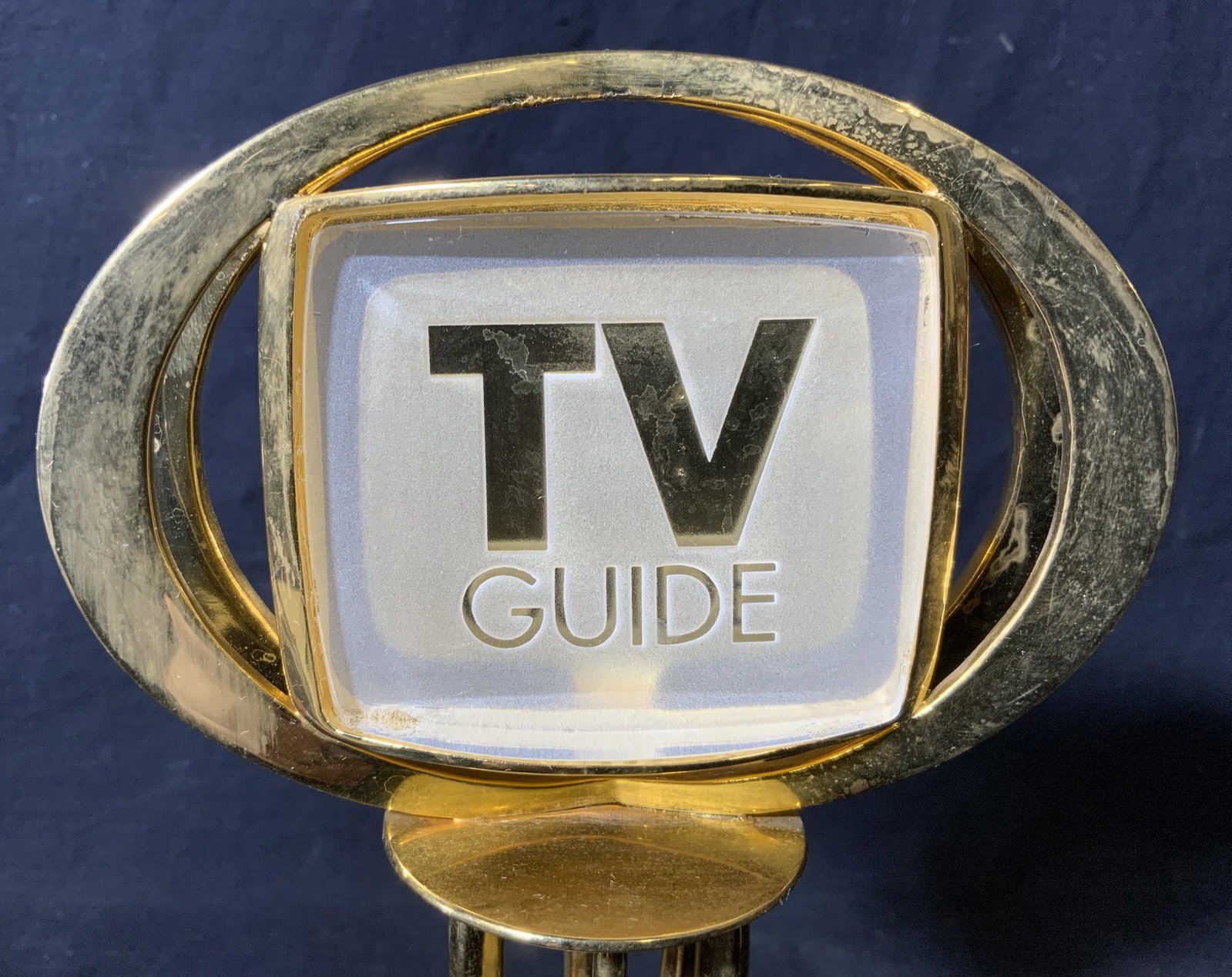 TV Guide Award: TV Guide Award, no apparent inscriptions or markings besides text to head of award that reads Â‘TV GuideÂ’, piece measures 11 inches at tallest point, base measures 4.5 inches by 3.75 inches, we